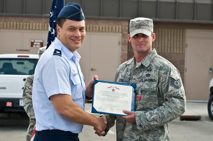 From left, U.S. Air Force Lt. Col. Aaron Young, 99th Civil Engineer Squadron commander, presents a Bronze Star to Tech. Sgt. Steven Stone, 99th Civil Engineer Squadron explosive ordinance disposal craftsman, Oct. 24, 2011, at Nellis Air Force Base, Nev. While assigned to the 9th Air Expeditionary Task Force Afghanistan,  Stone's leadership and dedication to duty were instrumental to the unit's combat operations. (U.S. Air Force photo by Airman 1st Class Matthew Lancaster/Released)