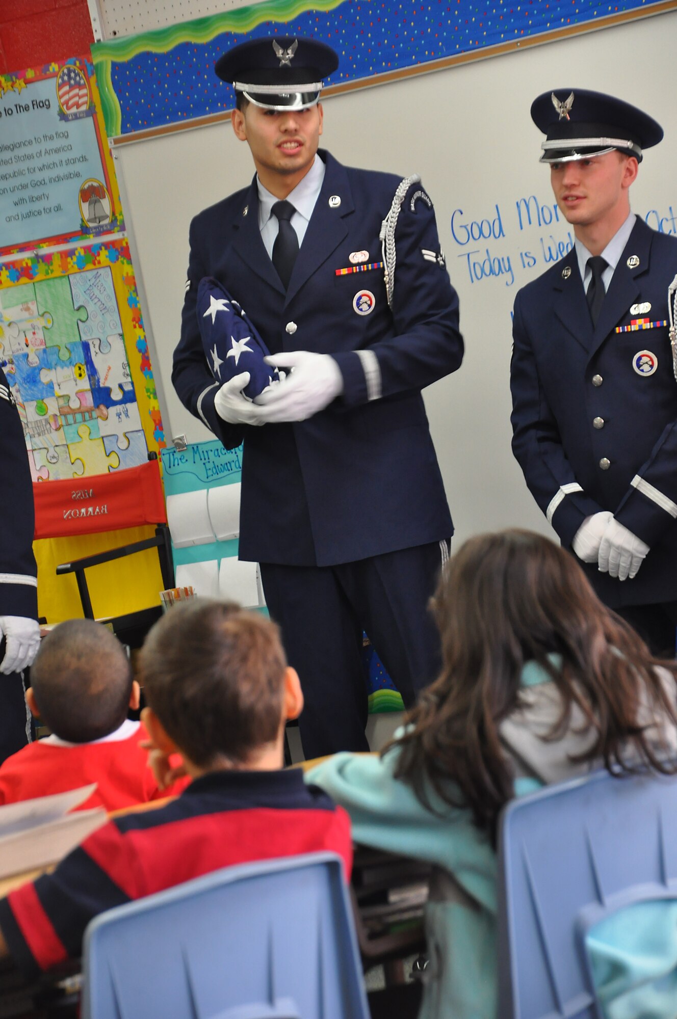 ANCHORAGE, Alaska -- Airman 1st Class Jose Mejia, left, answers questions about the US flag for a third grade class Oct. 19. Joint Base Elmendorf-Richardson honor guard members visited Abbott Loop Elementary school to demonstrate proper flag folding procedures as well as other military movements to students Oct. 19. (U.S. Air Force photo/Senior Airman Cynthia Spalding) 