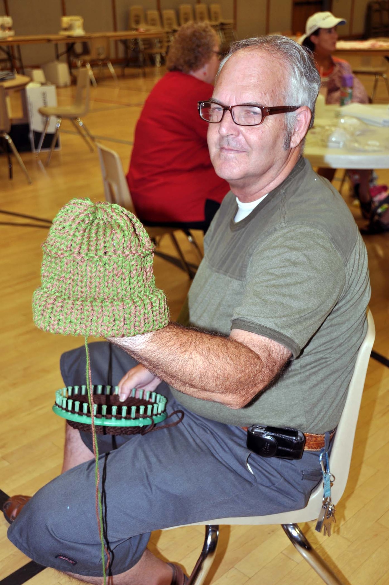 Richard Philbin, 62, of Redlands, Calif., makes a hat during a weekly volunteer session with Women of Faith in Redlands, Calif., for shipment to Afghanistan as part of humanitarian cargo through the Denton Amendment, a U. S. government program that offers free shipment for this cargo via military aircraft on a space available basis.  The group also donates to local hospitals.  (U.S. Air Force photo/Linda Welz)