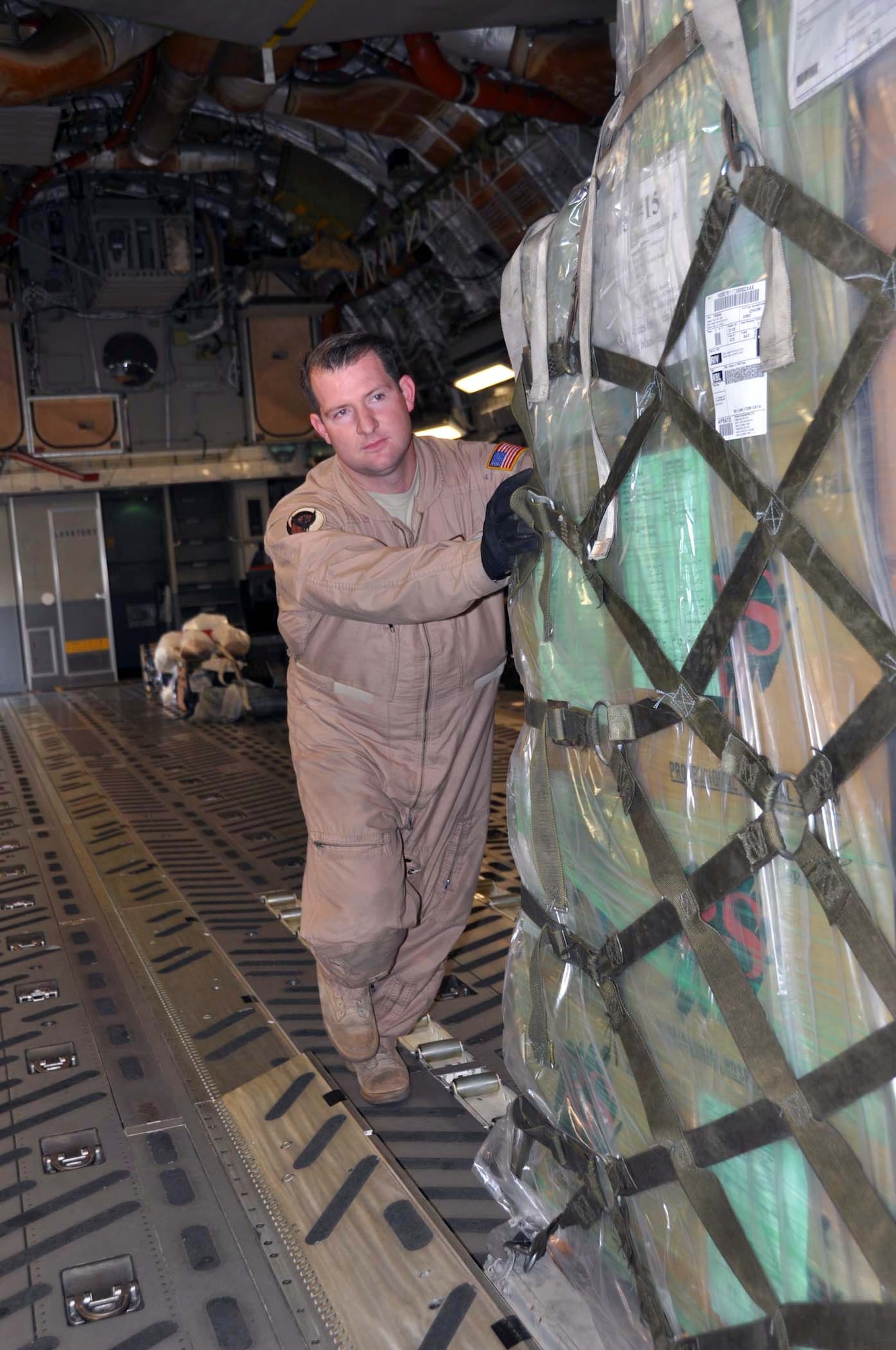 Tech. Sgt. Geoffrey Parish, 729th Airlift Squadron loadmaster, helps secure humanitarian supplies on a C-17 Globemaster III at March Field October 2, 2011.  Team March transported the cargo, donated by Women of Faith in Redlands, Calif., to Kabul, Afghanistan through the Denton Amendment program, a U.S. government program that allows humanitarian supplies to be shipped on military aircraft free of charge on a space available basis. (U.S. Air Force photo/Master Sgt. Linda Welz)