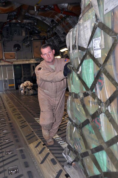 Tech. Sgt. Geoffrey Parish, 729th Airlift Squadron loadmaster, helps secure humanitarian supplies on a C-17 Globemaster III at March Field October 2, 2011.  Team March transported the cargo, donated by Women of Faith in Redlands, Calif., to Kabul, Afghanistan through the Denton Amendment program, a U.S. government program that allows humanitarian supplies to be shipped on military aircraft free of charge on a space available basis. (U.S. Air Force photo/Master Sgt. Linda Welz)