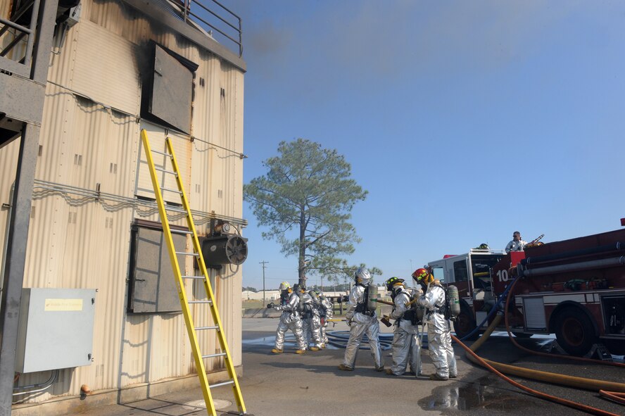 Firefighters from the 4th Civil Engineer Squadron prepare to enter a burning building during structural live-fire training on Seymour Johnson Air Force Base, N.C., Oct. 24, 2011. During the training the firefighters practice maneuvering in teams through a building while extinguishing fires in the process. (U.S. Air Force photo by Staff Sgt. Courtney Richardson)