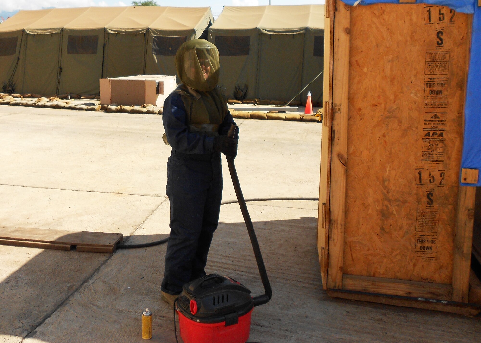 Air Force Reserve Master Sgt. Jennifer Alexander is shown displaying protective gear and a vacuum she uses to eradicate dangerous African bee populations impacting personnel at her U.S. Africa Command forward operating base.  In her duties as the deployed pest control manager, the Duke Field civil engineering Airman often works with host nation military officials to eliminate dangerous wildlife hazards and ensure non-threatening wildlife found on and near her base are safely returned to the wild. (Courtesy photo)
