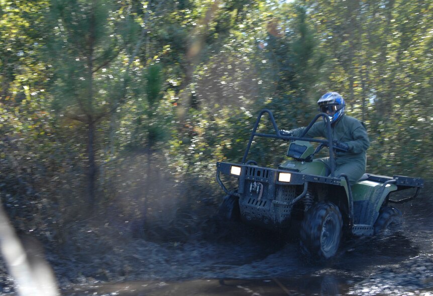 U.S. Air Force Staff Sgt. Clifford Sisk, 38th Rescue Squadron aircrew flight equipment assistant NCO in charge, rides through the mud Oct. 21, 2011, at Moody Air Force Base, Ga., during four-wheeler refresher training. Sisk and fellow 38th RQS members receive the training so they can operate the vehicles when deployed. (U.S. Air Force photo by Senior Airman Brigitte N. Brantley/Released)
