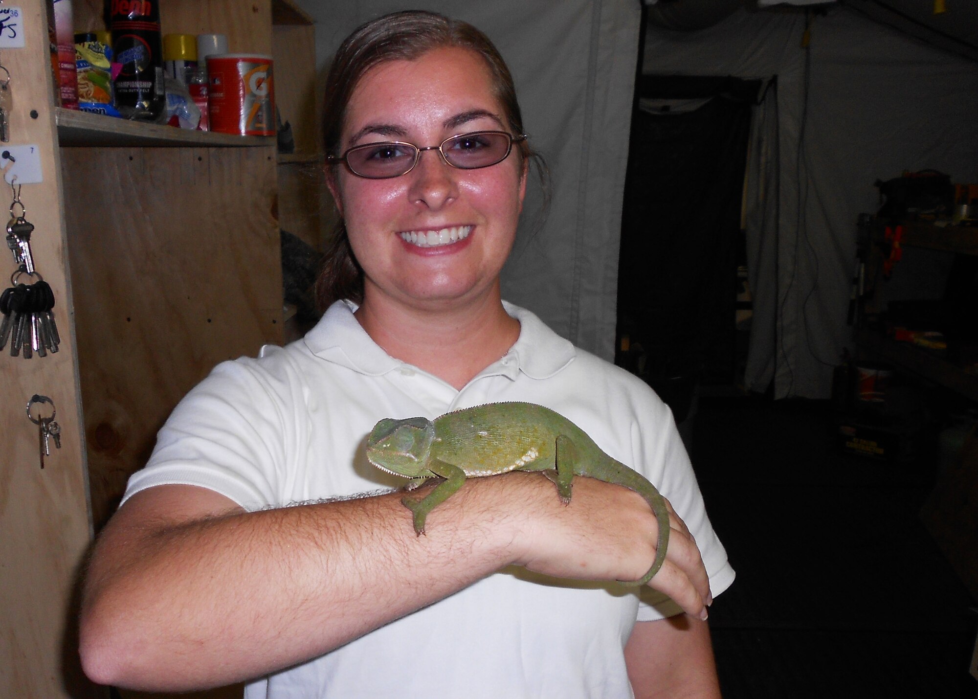 Air Force Reserve Master Sgt. Jennifer Alexander displays a chameleon she recently found at her deployed location.  In her duties as the deployed pest control manager for a U.S. Africa Command forward operating base, the Duke Field civil engineering Airman often works with host nation military officials to eliminate dangerous wildlife hazards and ensure non-threatening wildlife found on and near her base are safely returned to the wild. (Courtesy photo)