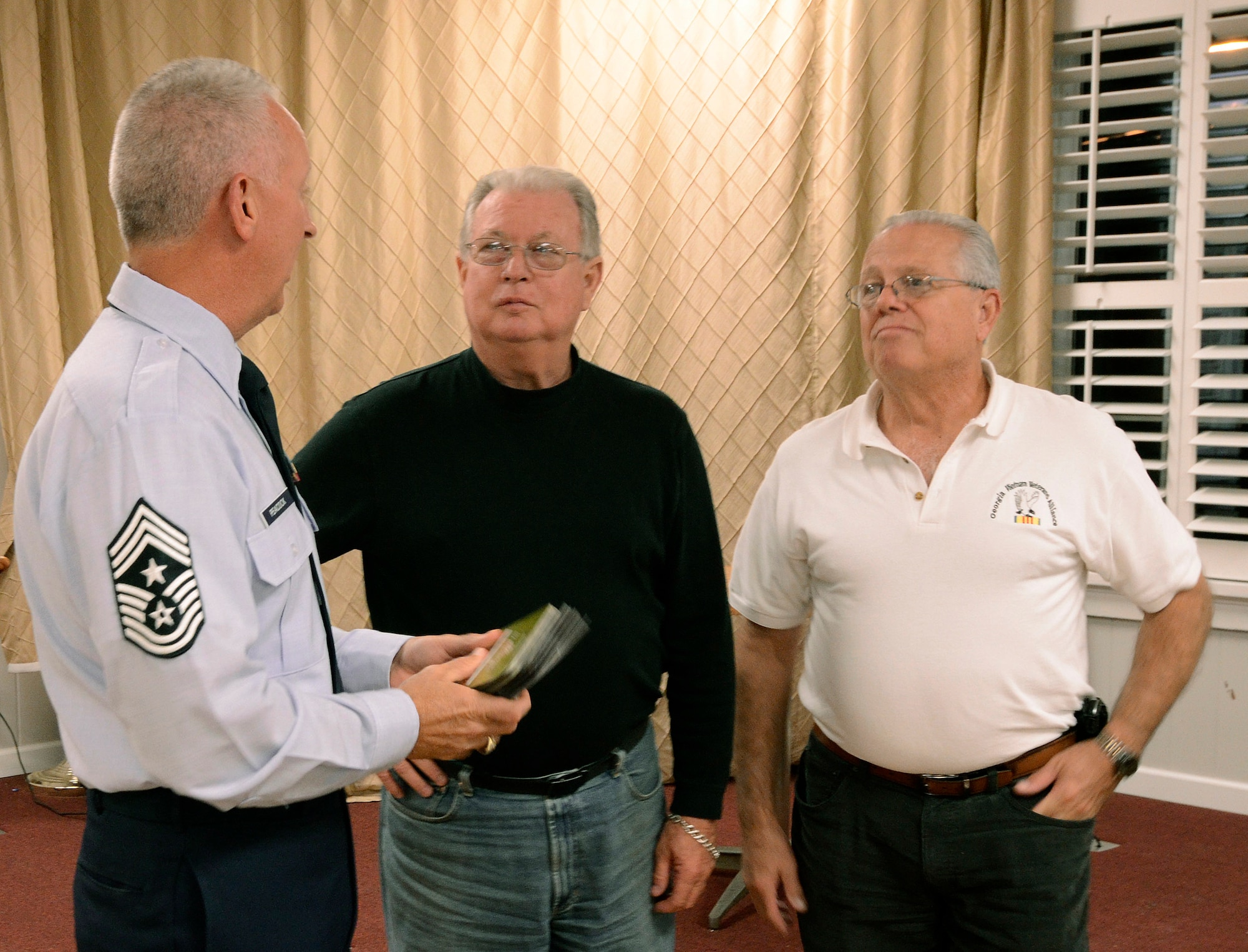 Chief Master Sgt. Wendell Peacock, Command Chief for the 94th Airlift Wing at Dobbins Air Reserve Base, accepts 40 gift vouchers valued at $50 each from  Bob Humphries, vice president, and Bill Kalish, president of the Georgia Vietnam Veterans Alliance, chapter one,  in Marietta, Ga., Oct. 20. The Marietta Chapter contributed the vouchers to help out military members on Dobbins during the holidays. The mission of the alliance is to provide quality services and support to veterans to help with their self-esteem and encourage them to be self reliant.   (U.S. Air Force photo/ Brad Fallin)