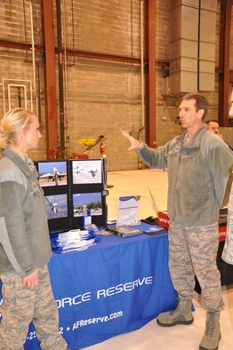 Col. Bryan Radliff, 477th Fighter Group commander, discusses the groups recruiting efforts with Staff Sgt. Sammy Jeffery, an Air Force Reserve recruiter, at a spouses job fair on Joint Base Elmendorf Richardson, Oct. 14. 