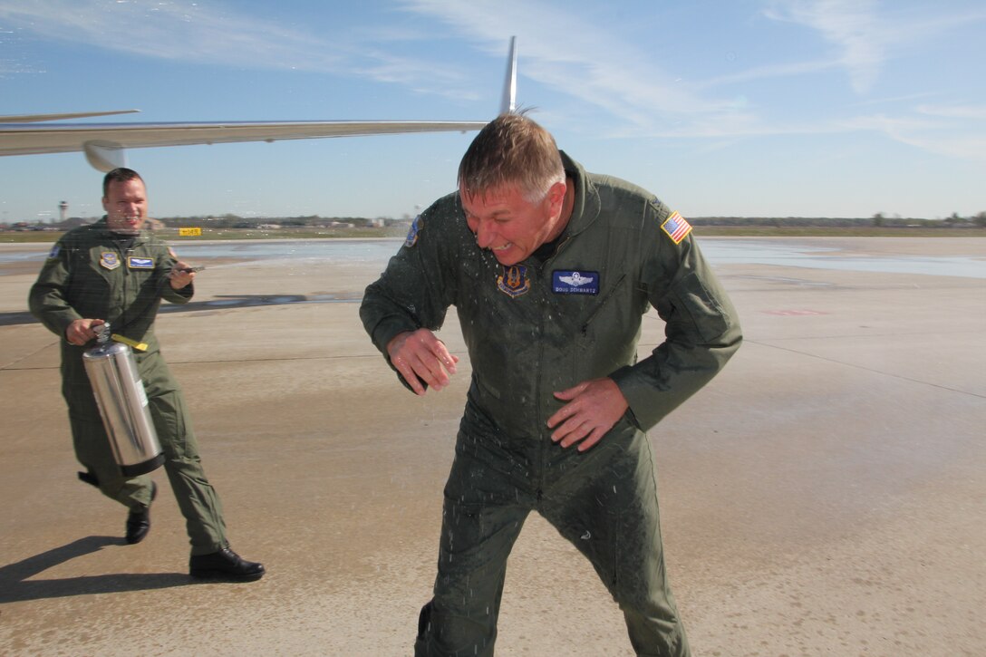 Col. Douglas Schwartz, vice-commander of the 932nd Airlift Wing, gets doused following his "fini" flight on the C-40C.  Family, friends and fellow aircrew took turns spraying down Schwartz on the Scott Air Force Base flight line.  Schwartz has been at the 932nd since 2009 and now moves to his new assignment at Fourth Air Force, March Air Reserve Base, Calif.  (U.S. Air Force photo/Tech. Sgt. Dan Oliver)