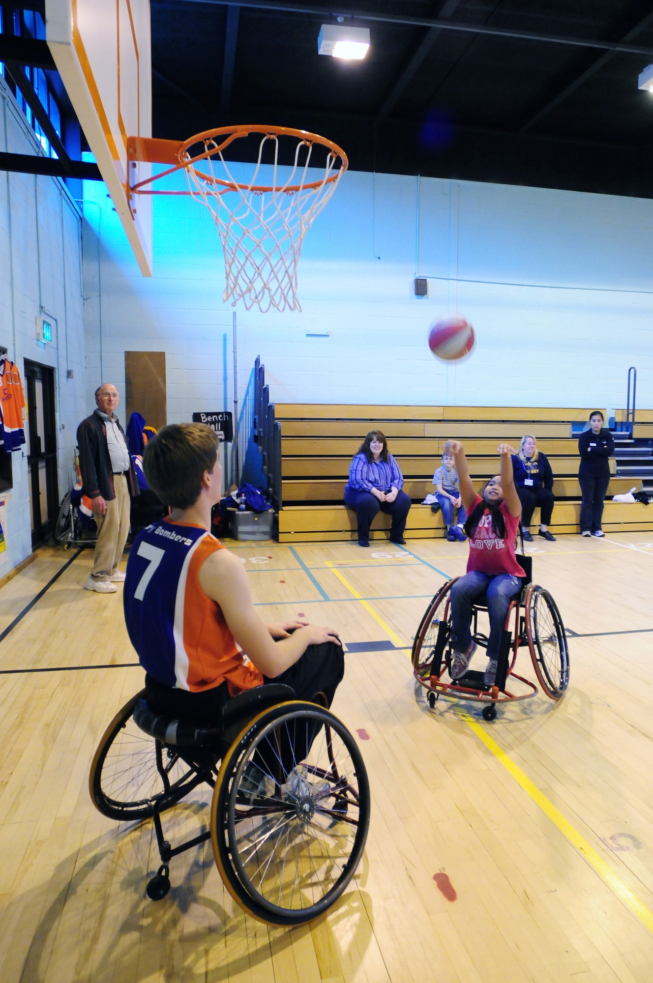 ROYAL AIR FORCE LAKENHEATH, England - Jordan Hughes, Bury Bombers basketball player, watches Andrea Pampuan, 8, shoot the ball during the hands-on session of the Bury Bombers visit to Lakenheath Elementary School, Oct. 25, 2011. Sponsored by the Parent Teacher Student Organization, the Bury Bombers also performed an exhibition game for all the students for the fifth year in a row. (U.S. Air Force photo by Senior Airman Lausanne Morgan)