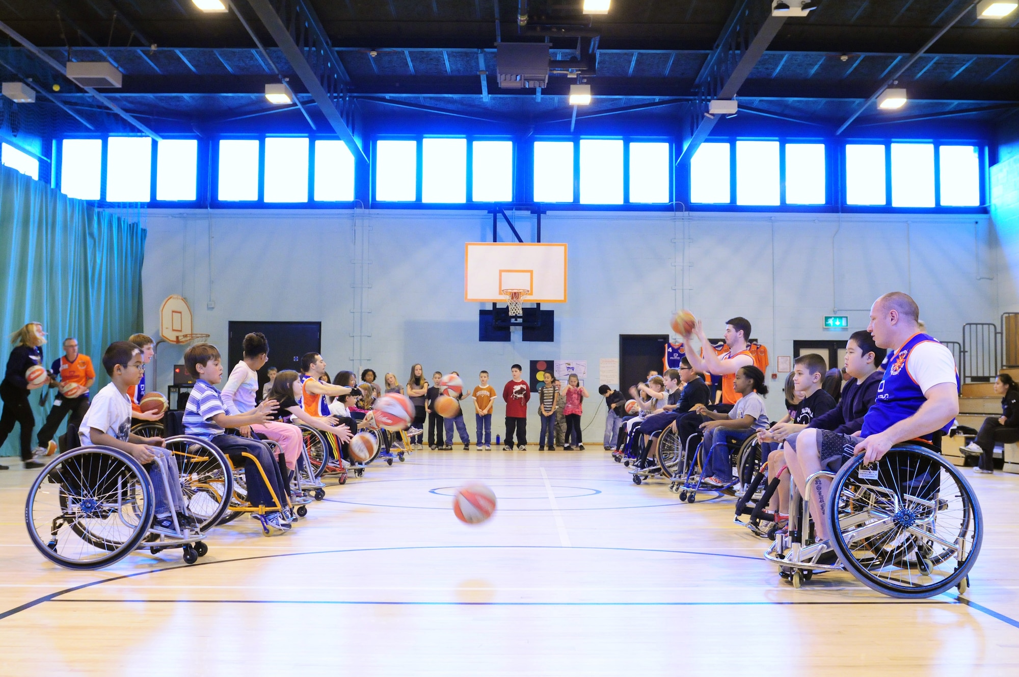 ROYAL AIR FORCE LAKENHEATH, England - Lakenheath Elementary School students practice holding, passing and dribbling the basketball while in wheelchairs during the hands-on session of the Bury Bombers visit to Lakenheath Elementary School, Oct. 25, 2011. Sponsored by the Parent Teacher Student Organization, the Bury Bombers also performed an exhibition game for all the students for the fifth year in a row. (U.S. Air Force photo by Senior Airman Lausanne Morgan)