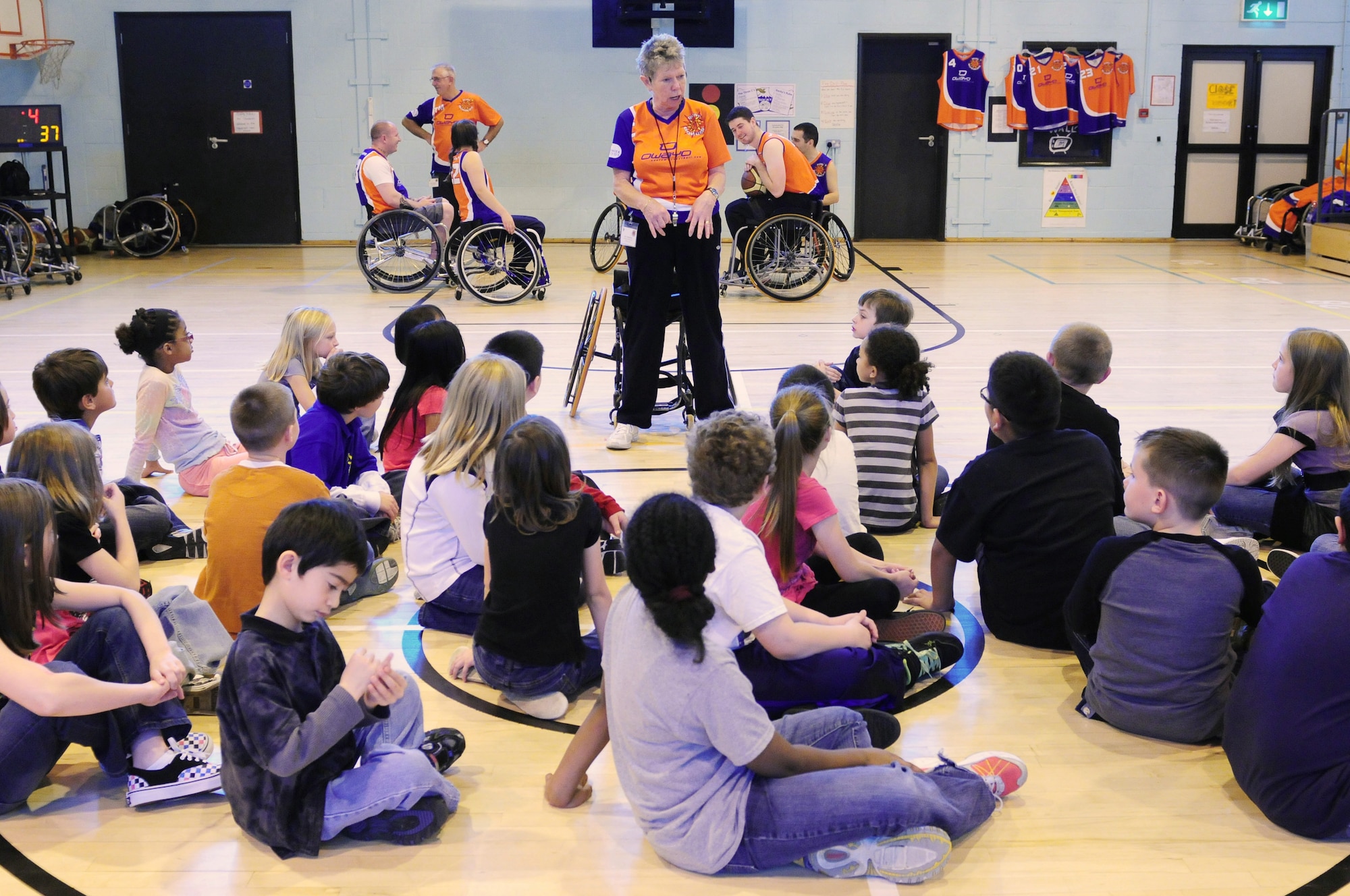 ROYAL AIR FORCE LAKENHEATH, England - Jill Anderson, Bury Bombers head coach, prepares to demonstrate how to sit properly in a wheelchair to Lakenheath Elementary School students, Oct. 25, 2011. Sponsored by the Parent Teacher Student Organization, the Bury Bombers visited the school to perform an exhibition game for all the students for the fifth year in a row. After the game, due to the size of the wheelchairs, third grade students were given the opportunity to have a hands-on session with the players. (U.S. Air Force photo by Senior Airman Lausanne Morgan)