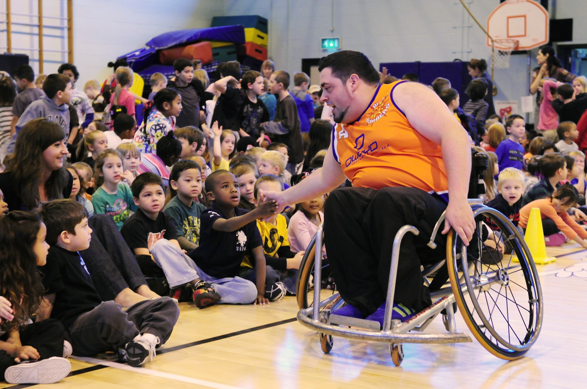 ROYAL AIR FORCE LAKENHEATH, England - Chris Rix, Bury Bomber basketball player, shakes hands of Lakenheath Elementary School students after a basketball game, Oct. 25, 2011. Sponsored by the Parent Teacher Student Organization, the Bury Bombers visited the school to perform an exhibition game for all the students for the fifth yeaar in a row. After the game, due to the size of the wheelchairs, third grade students were given the opportunity to have a hands-on session with the players. (U.S. Air Force photo by Senior Airman Lausanne Morgan)