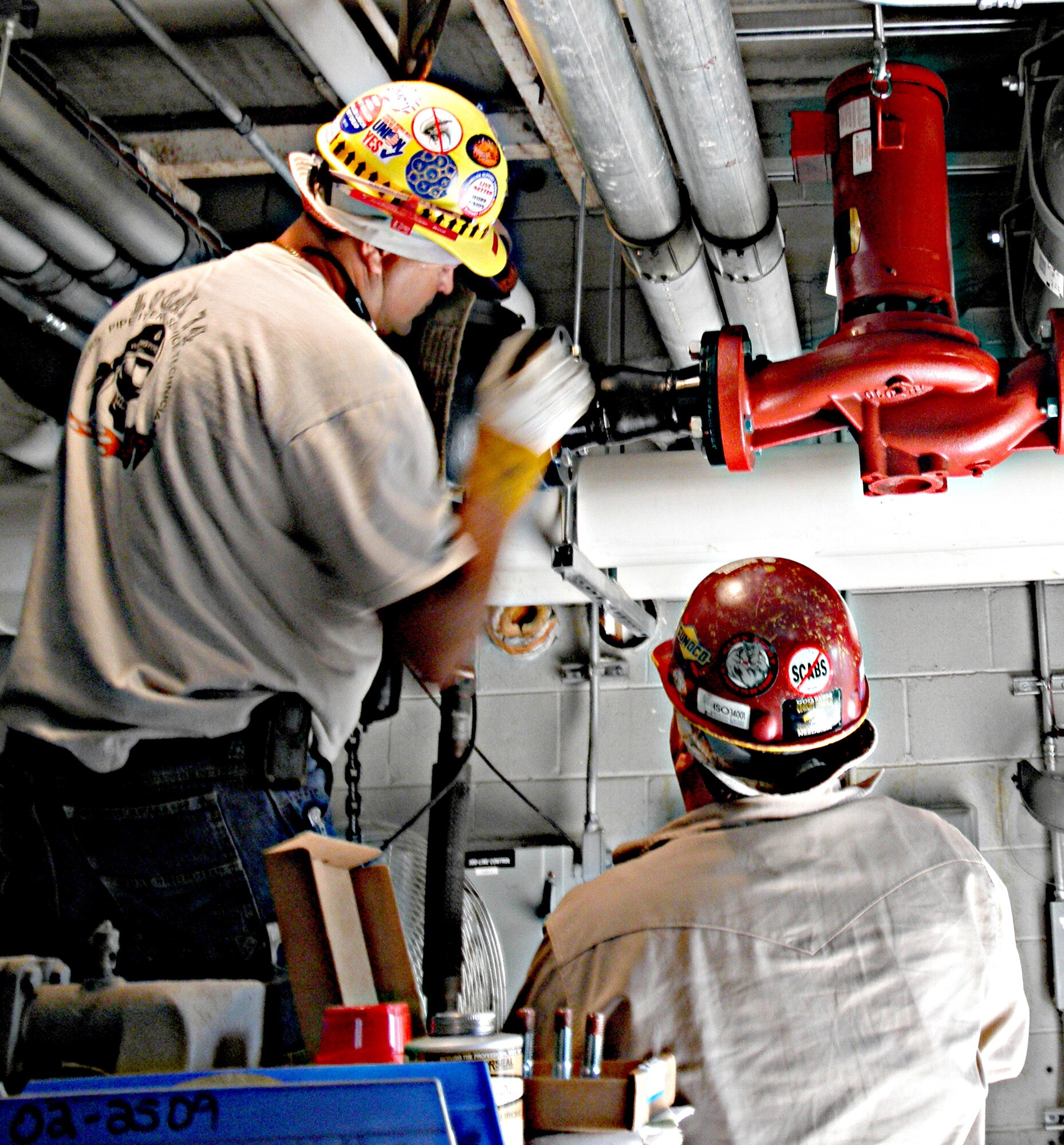 Contractors tie in a new boiler pump July 13, 2011, at Building 721 at Dover Air Force Base, Del. The new boilers are part of the heat plant decentralization project, which will help Dover AFB reduce its energy use more than 15 percent a year. (U.S. Air Force courtesy photo) 