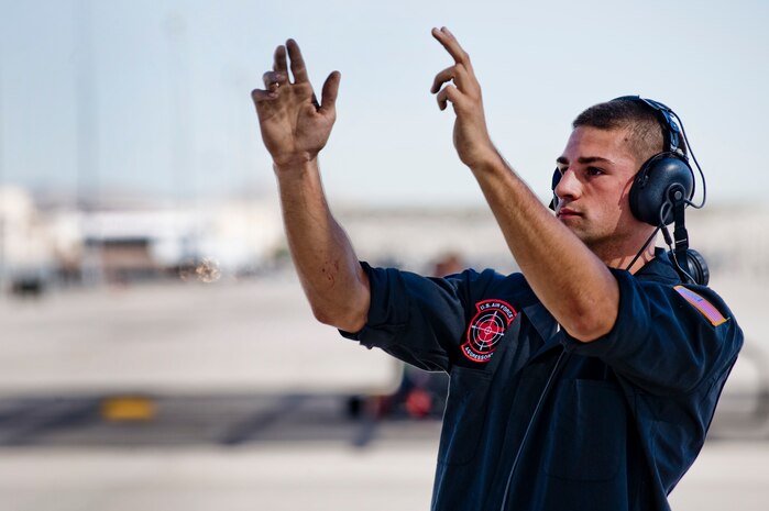 U.S. Air Force Airman 1st Class Michael Summet, 757th Aircraft Maintenance Squadron crew chief, marshals Capt. David Vincent, 65th Aggressor Squadron pilot, for the first flight of an F-15 Eagle with an updated "Splinter" paint scheme Oct. 20, 2011, at Nellis Air Force Base, Nev.  The updated Russian paint scheme promotes realistic threat replication when participating in simulated air to air combat.  (U.S. Air Force photo by Staff Sgt. William P.Coleman/Released)