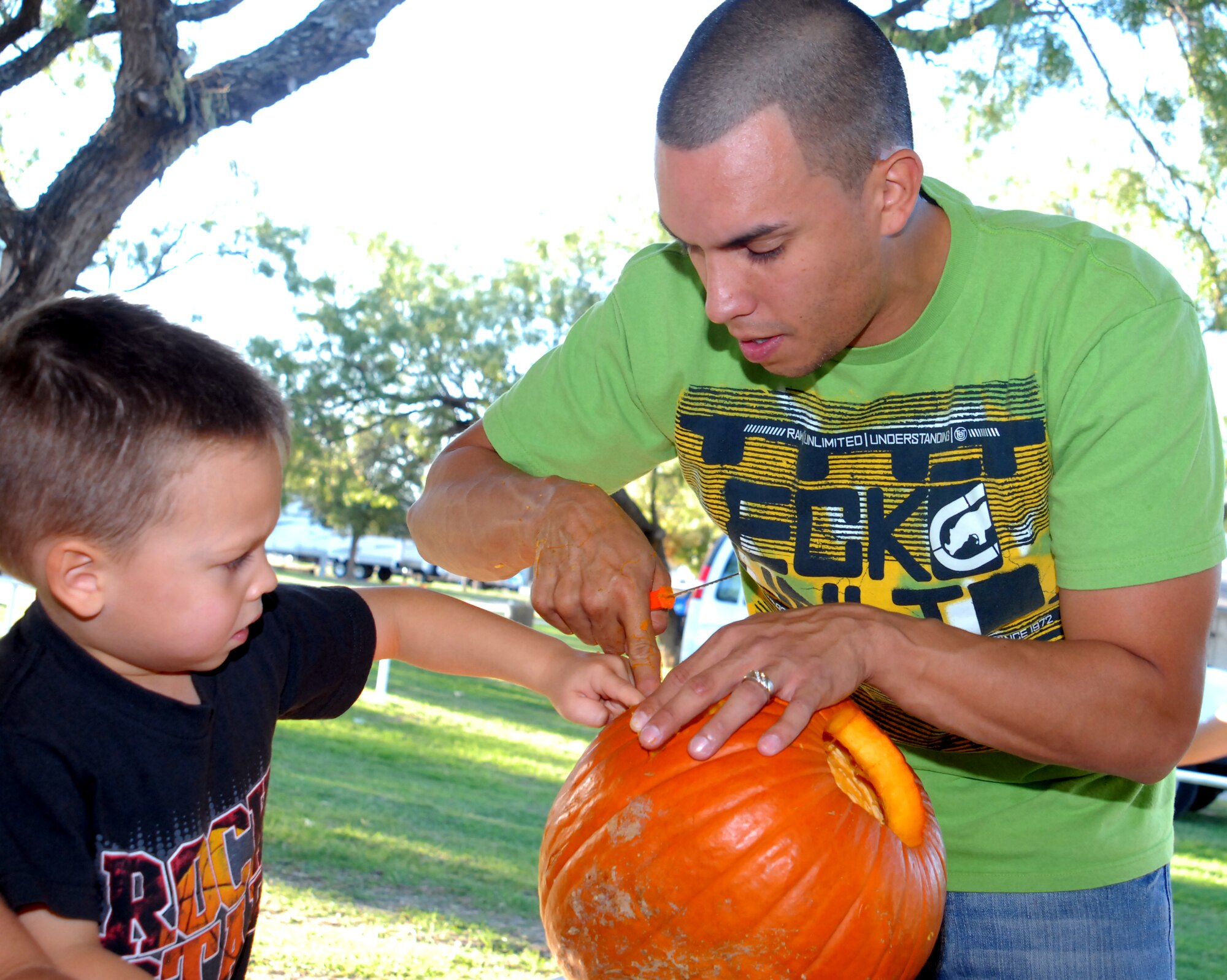 SAN ANGELO, Texas – Isaiah Estrada helps his dad Staff Sgt. Carlos Estrada, 315th Training Squadron, push the eyes out of his Halloween pumpkin during Family Night at the Recreation Camp Oct. 24.  More than 20 families participated in the event, which had a hayride, pumpkin carving and hot dogs. The next Family Night is scheduled for Nov. 21 from 5:30-7 p.m. at the Event Center with free pie building and craft projects, and food for purchase. FMI: (325) 654-3247. (U.S. Air Force photo/Connie Hempel)