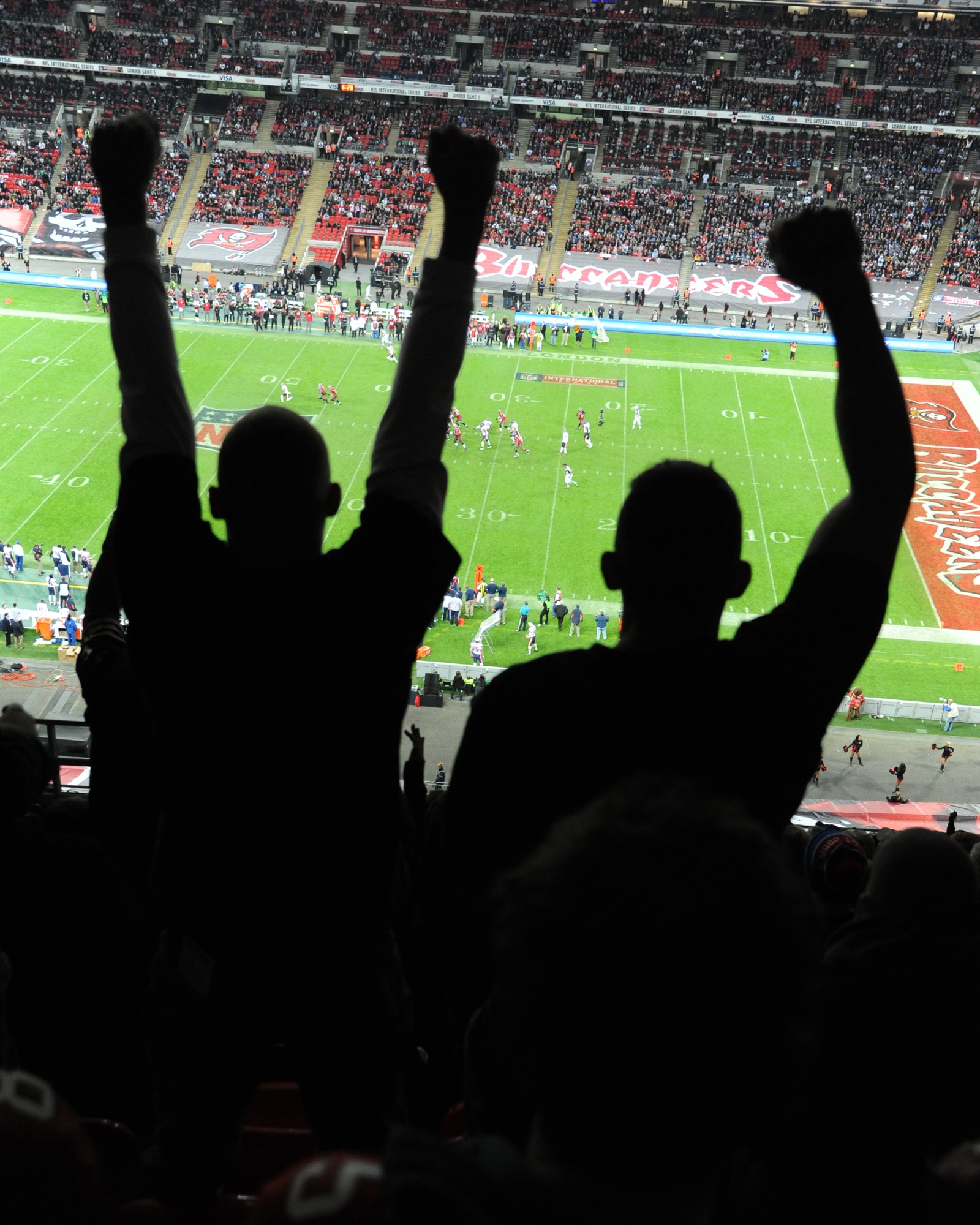 LONDON - U.S. Service members file among the ranks of Tampa Bay Buccaneers and Chicago Bears fans as they support their team during a NFL event hosted at Wembley Stadium, London, Oct. 23, 2011. More than 500 Royal and U.S. Air Force Airmen ran onto the field, some carrying an enormous 150-foot Buccaneers flag and others filing into formations with red, white or blue plastic pieces to silhouette the American and U.K. flags as opera singers Noah Stewart sang the ‘Star Spangled Banner,’ and Katherine Jenkins sang ‘God Save the Queen.’ (U.S. Air Force photo/Staff Sgt. Tabitha Lee)