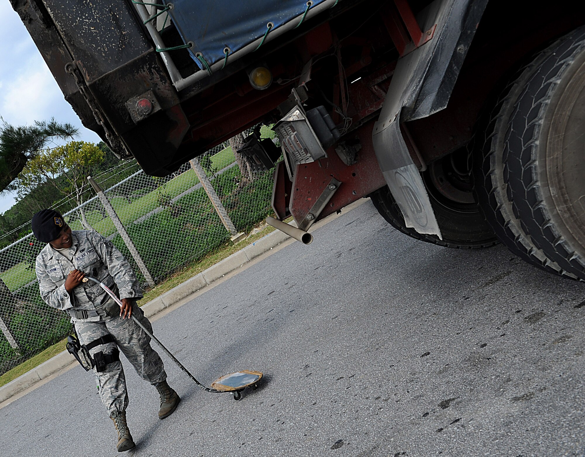 U.S. Air Force Airman 1st Class Ashtin Alston, 18th Security Forces Squadron installation entry controller, sweeps a vehicle for explosive devices and other paraphernalia Oct. 25 on Kadena Air Base, Japan. Although Team Kadena is currently participating in local operational readiness exercise Beverly High 12-1, real-world mission requirements must still be met. (U.S. Air Force photo/Staff Sgt. Christopher Hummel/released)
