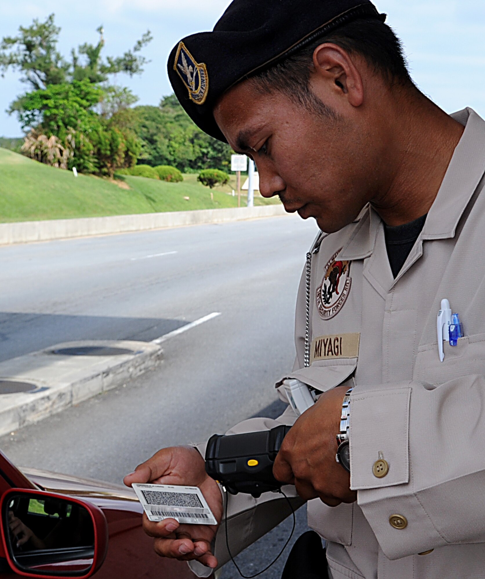 Government of Japan civilian guard Shoya Miyagi, 18th Security Forces Squadron installation entry controller, scans the identification card of a military dependent Oct. 25 on Kadena Air Base, Japan. Although Team Kadena is currently participating in local operational readiness exercise Beverly High 12-1, real-world mission requirements must still be met. (U.S. Air Force photo/Staff Sgt. Christopher Hummel/released)