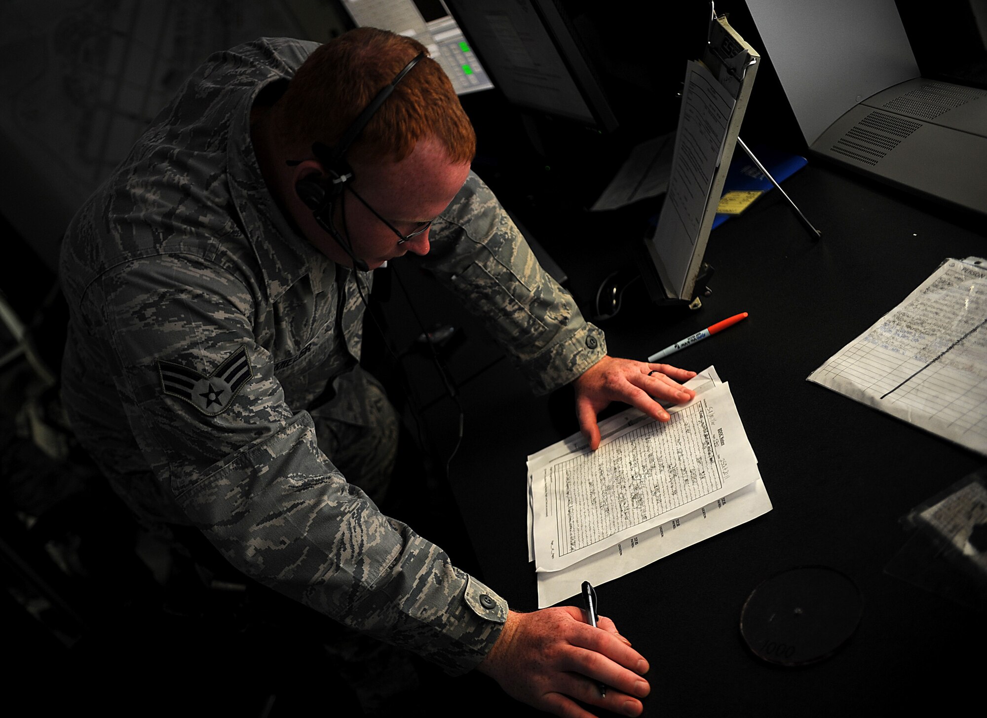 U.S. Air Force Senior Airman Daniel Miller, 18th Security Forces Squadron desk sergeant, reviews law enforcement desk notes as part of his daily duties Oct. 25 on Kadena Air Base, Japan. Although Team Kadena is currently participating in local operational readiness exercise Beverly High 12-1, real-world mission requirements must still be met. (U.S. Air Force photo/Staff Sgt. Christopher Hummel/released)