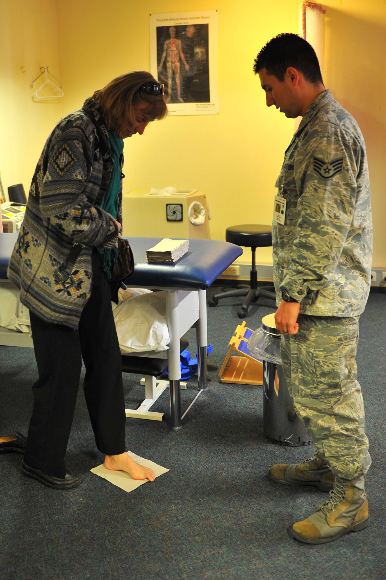 SPANGDAHLEM AIR BASE, Germany – Cathron Donaldson, left, 52nd Medical Operations Squadron Educational and Developmental Intervention Services physical therapist, uses water and a paper towel to check the arch of her foot while Staff Sgt. Joseph Suarez, 52nd Medical Operations Squadron physical therapist, assists in determining the type of shoe best suited for her foot during the physical therapy open house here Oct. 21. The open house allowed guests to learn about preventative safety measures for working out and enabled the clinic to showcase the services they provide to Airmen and families. (U.S. Air Force photo/Airman 1st Class Dillon Davis)