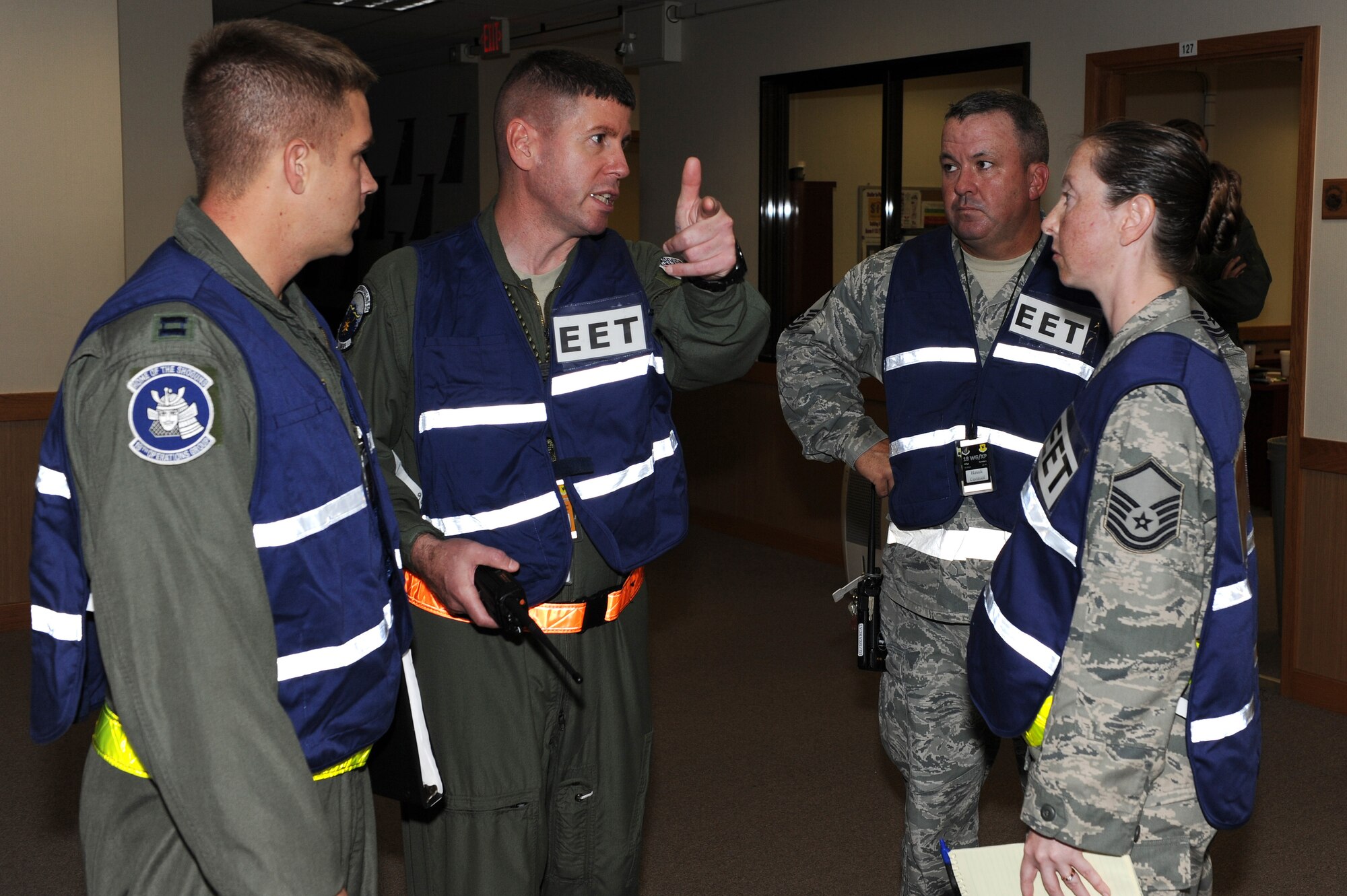 U.S. Air Force Capt. Stephen Grantier, Senior Master Sgt. Michael Steinkraus, Master Sgt. Brent Sanders and Master Sgt. Andrea Barnes, 18th Wing exercise evaluation team members, discuss a suicide bomber scenario at the 909th Air Refueling Squadron during Beverly High 12-1, a local operational readiness exercise on Kadena Air Base, Japan, Oct. 25. During the LORE, many EET members are on-scene to evaluate Airmen in ways such as safety and immediate reaction. (U.S. Air Force photo/Junko Kinjo/Released) 