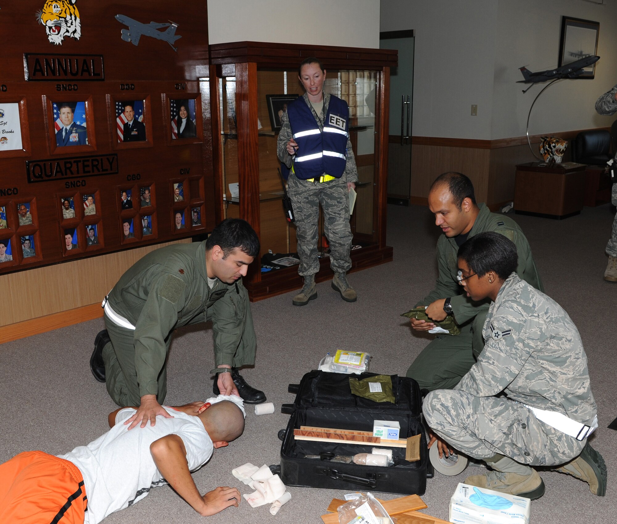 U.S. Air Force Master Sgt. Andrea Barnes, 18th Wing Plans superintendent of exercises, evaluates how Airmen apply self-aid and buddy care to an injured Airman during a  suicide bomber scenario at the 909th Air Refueling Squadron during Beverly High 12-1, a local operational readiness exercise on Kadena Air Base, Japan, Oct. 25. During the LORE, many EET members are on-scene to evaluate Airmen in ways such as safety and immediate reaction. (U.S. Air Force photo/Junko Kinjo/Released) 