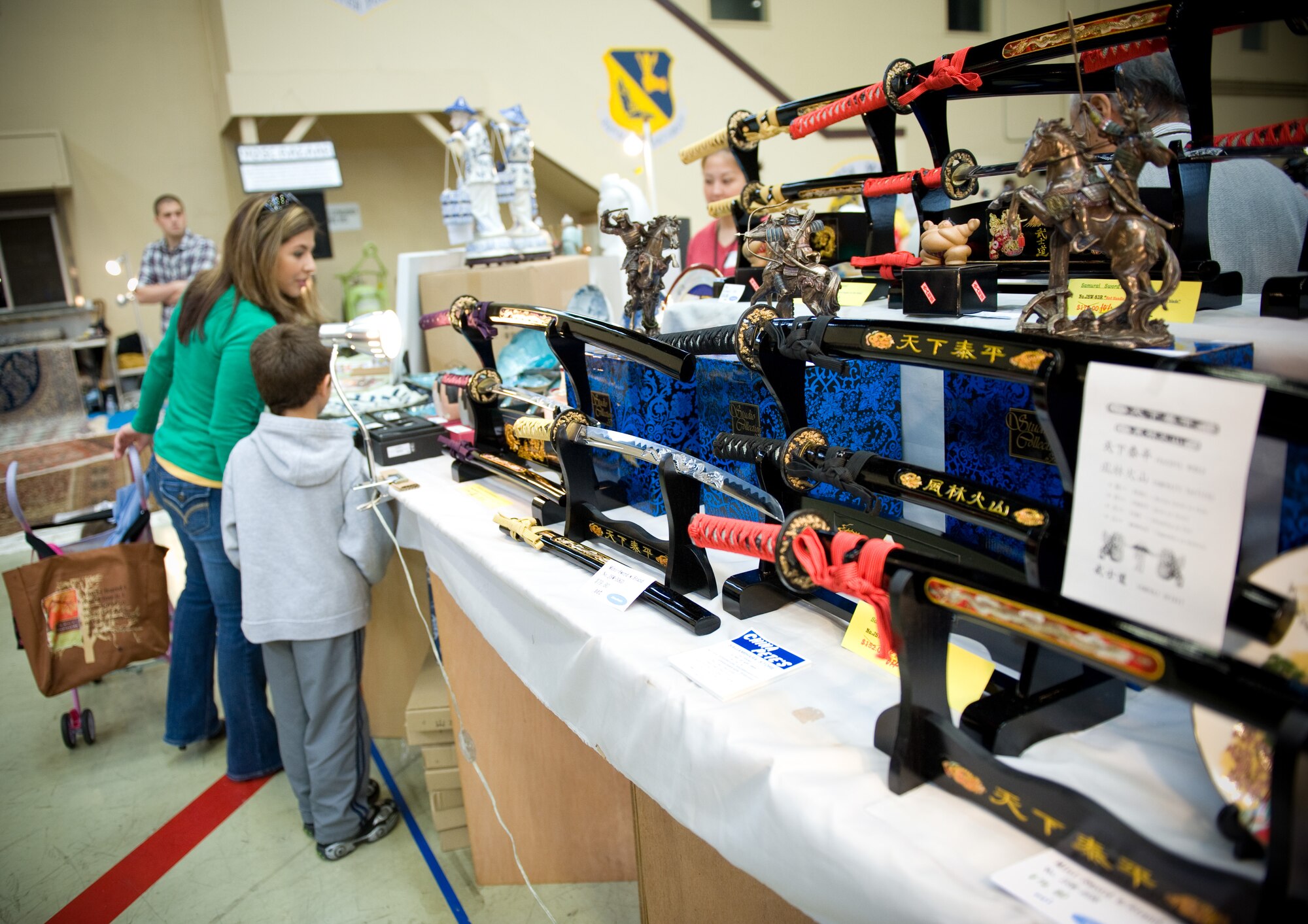 YOKOTA AIR BASE, Japan -- Patrons of Yokota Officer Spouses Club Fall Bazaar look at Samurai swords at Yokota Air Base, Japan, Oct. 22, 2011. Products at the bazaar ranged from children's toys to expensive collector items. (U.S. Air Force photo/Airman 1st Class Krystal M. Garrett) 