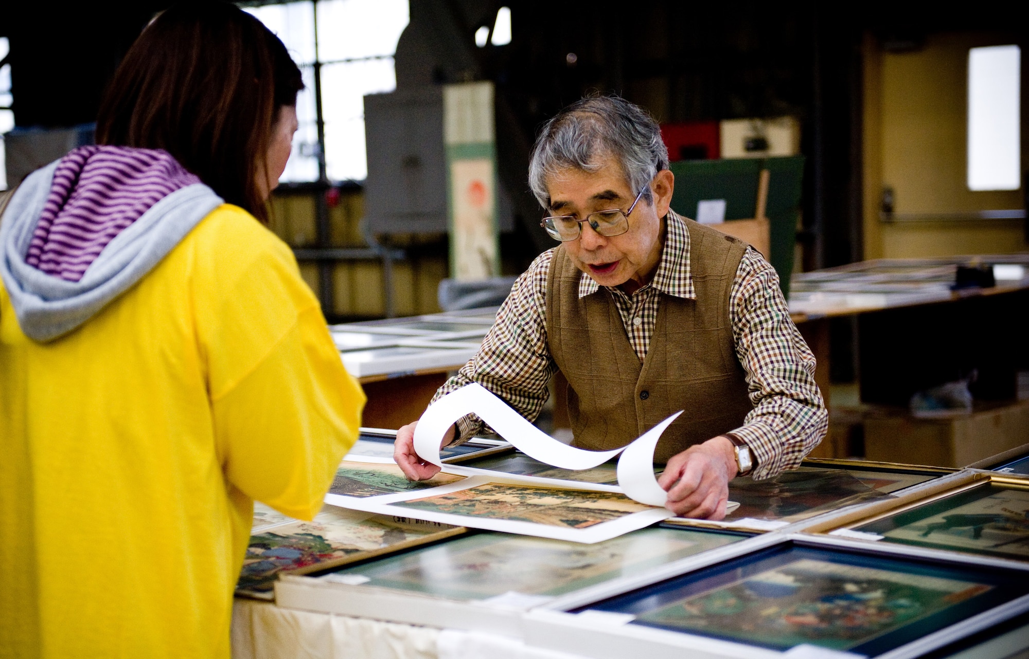 YOKOTA AIR BASE, Japan -- A vendor shows a piece of artwork to a customer at the Yokota Officer Spouses Club Fall Bazaar held at Yokota Air Base, Japan, Oct. 22, 2011. More than 47 vendors participated in the fall bazaar selling items from several different countries. (U.S. Air Force photo/Airman 1st Class Krystal M. Garrett) 