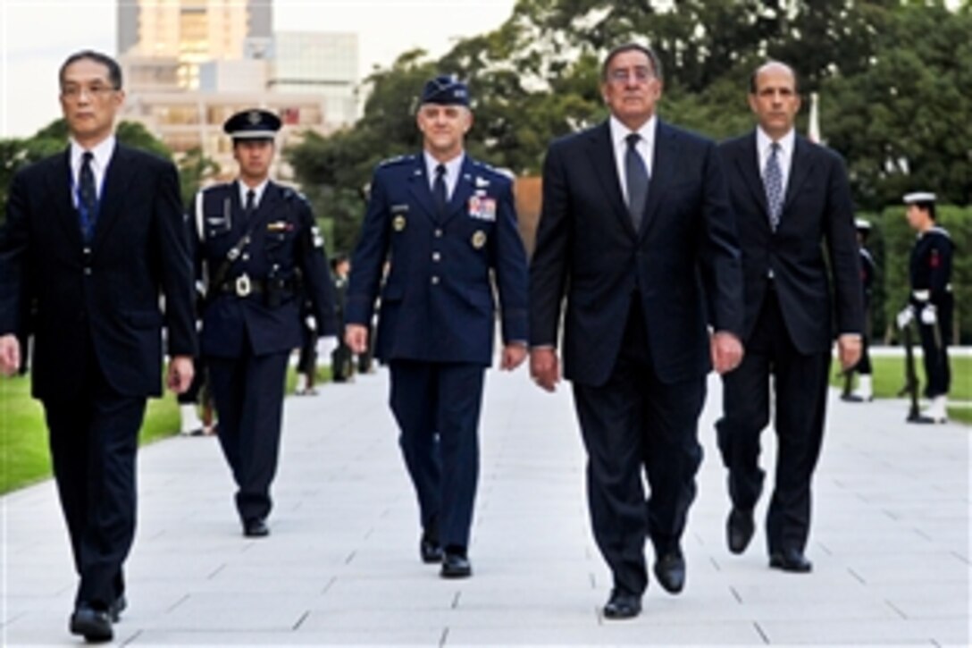 U.S. Defense Secretary Leon E. Panetta attends a wreath-laying ceremony with Tetsuro Kuroe, deputy director general of the Japanese Bureau of Defense Policy, far left, honoring the Japanese Self-Defense Forces, who died in service of their country at a memorial in Tokyo, Oct. 25, 2011. 