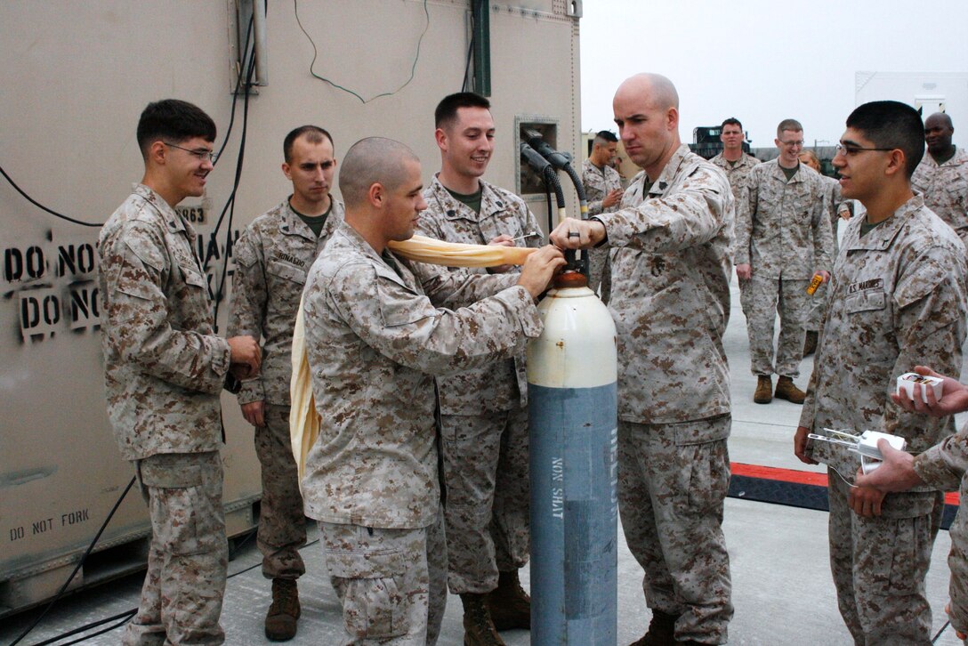 Staff Sgt. Michael E. Fitch and Sgt. Jonathan Macdonald, meteorology oceanography analyst forecasters, assist Sgt. Travis W. Patton, a meteorology oceanography analyst forecaster, with filling a weather ballon with helium here Oct. 19. Weather ballons expand to approximatly 300-grams but can expand up to the size of a small house before it bursts, which may happen at 70,000 feet above sea level. With the technology shrinking, Rawinsonde are easier to carry and launch. While deployed, Rawinsonde are used more often and may be the only source of weather information available. The new technology is still on backorder for fleet bases but the new equipment hasn’t had any major problems or defects arise since its release in the field.