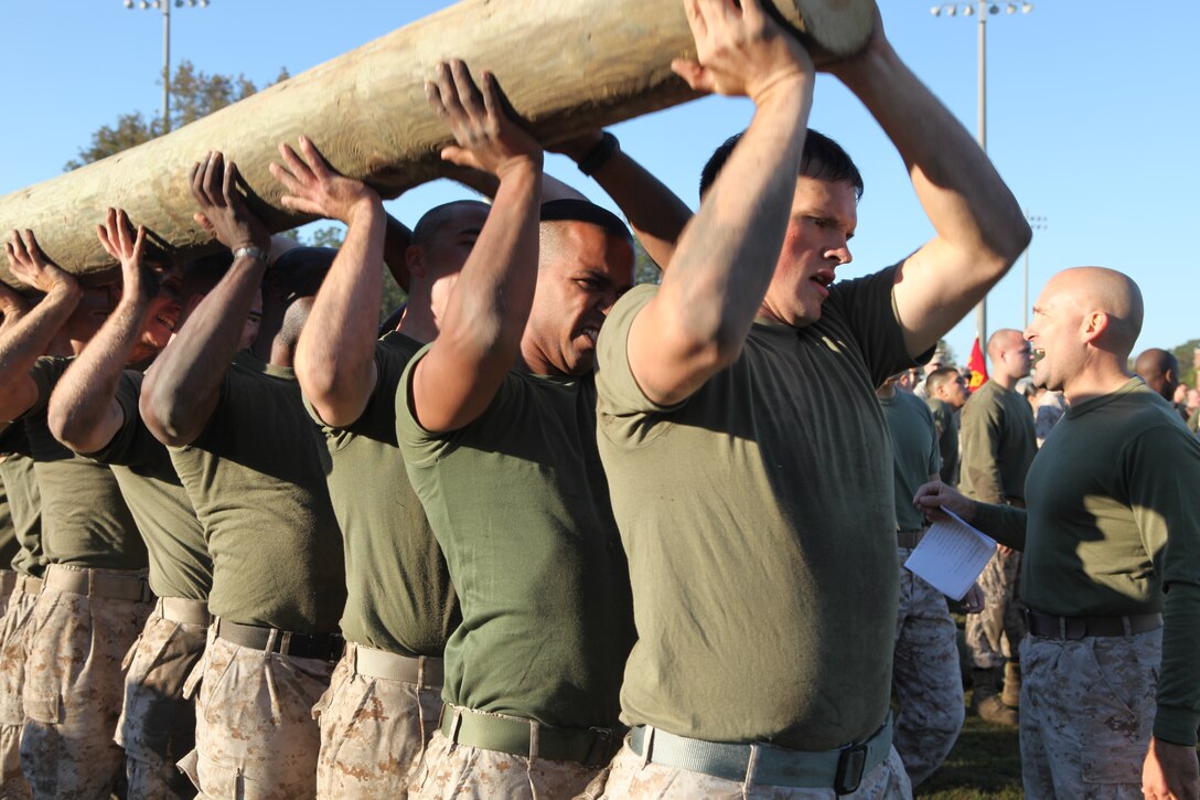 Marines endure pain during the super squad log press portion of the Headquarters and Support Battalion Commanders Cup Challenge field meet aboard Marine Corps Base Camp Lejeune, Oct. 26.