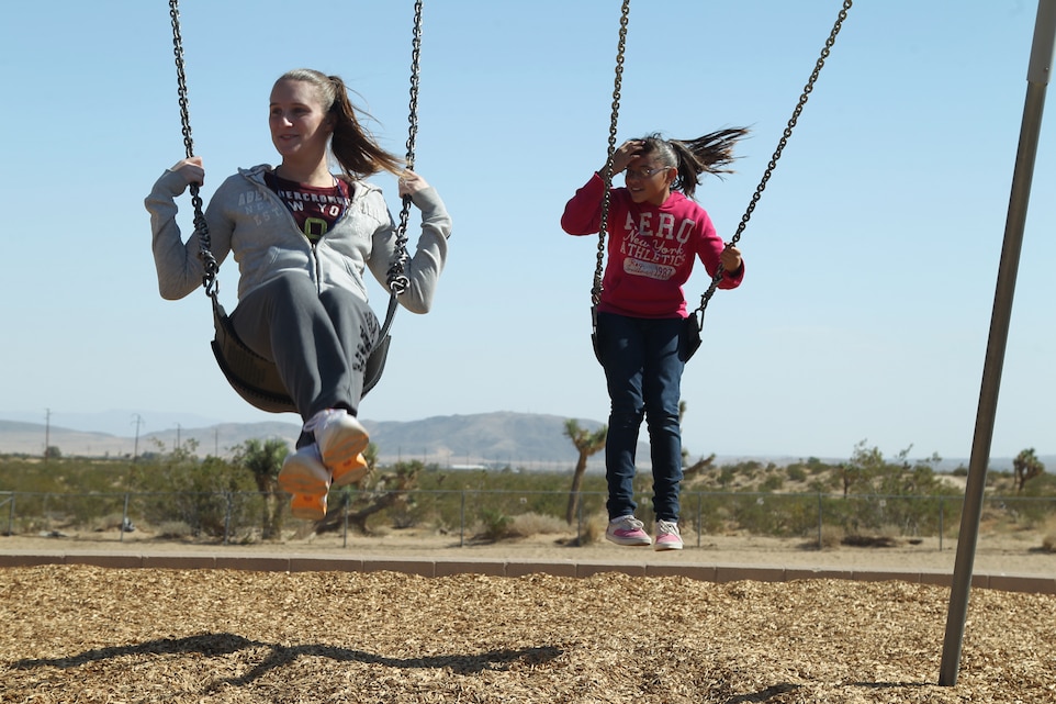 Cpl. Kelly Devos [left], an administrative clerk with Marine Wing Support Squadron 374, swings with Angela Sheperd, 10, a Joshua Tree Elementary student, when MWSS-374 went to the school as part of the Adopt-A-School program Oct. 26, 2011.::r::::n::