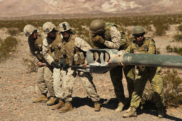 Marines with Battery I, 3rd Battalion, 11th Marine Regiment, work with Australian soldiers with 1st Brigade, 8/12, to align Gun Five on the firing line during cross training in support of Enhanced Mojave Viper Oct. 26, 2011, at Quackenbush range.