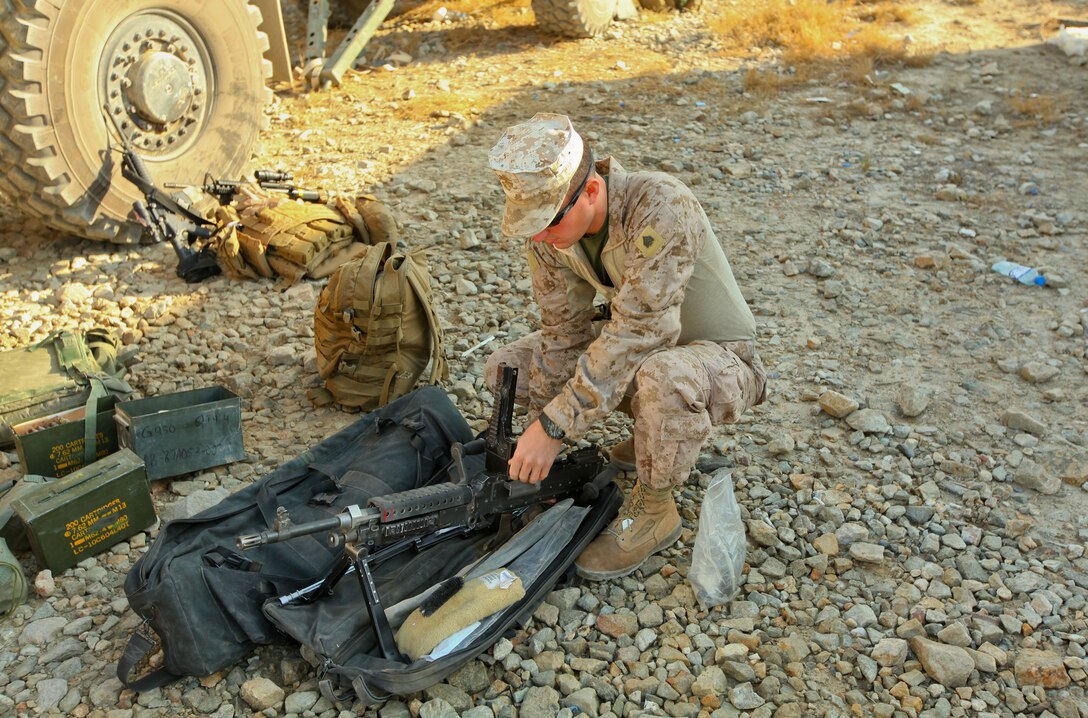 Sgt. Justin Hale, an Everett, Wash., native and communications mentor with Embedded Partnering Team, 2nd Marine Logistics Group (Forward), lays out parts of a 240G machine gun before cleaning them as part of a preventative maintenance measure before a convoy, Oct. 27. Habits like these are passed on to Afghan National Army soldiers mentored by Hale and other members of the team.