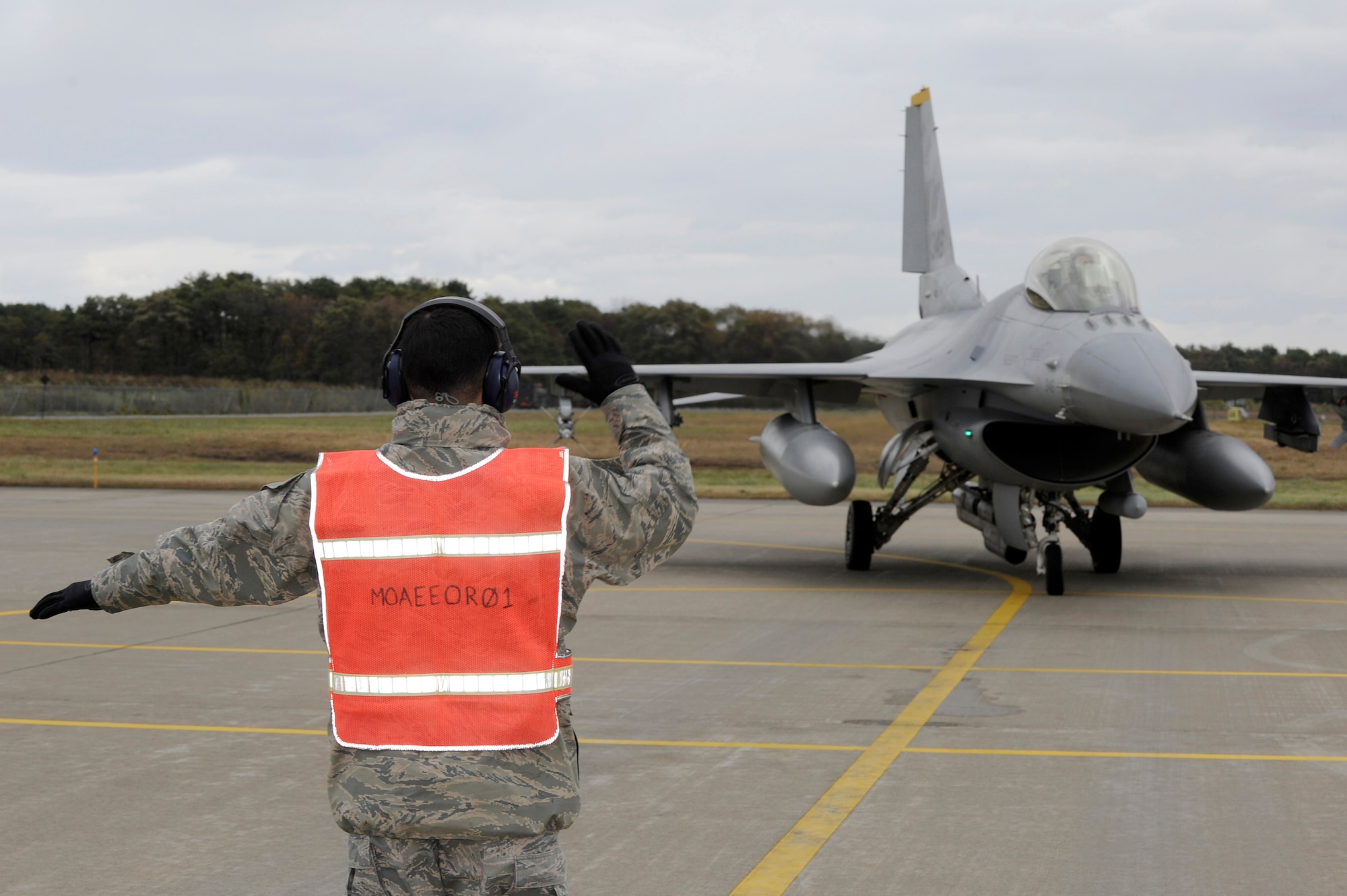 MISAWA AIR BASE, Japan - U.S. Air Force Staff Sgt. Cyle Delucca, 14th Aircraft Maintenance Unit, marshals an F-16 Fighting Falcon during the end-of-runway inspection here Oct. 26. The purpose of EOR is to arm the munitions on the jet and ensure it is safe to fly. (U.S. Air Force photo/Tech. Sgt. Marie Brown)