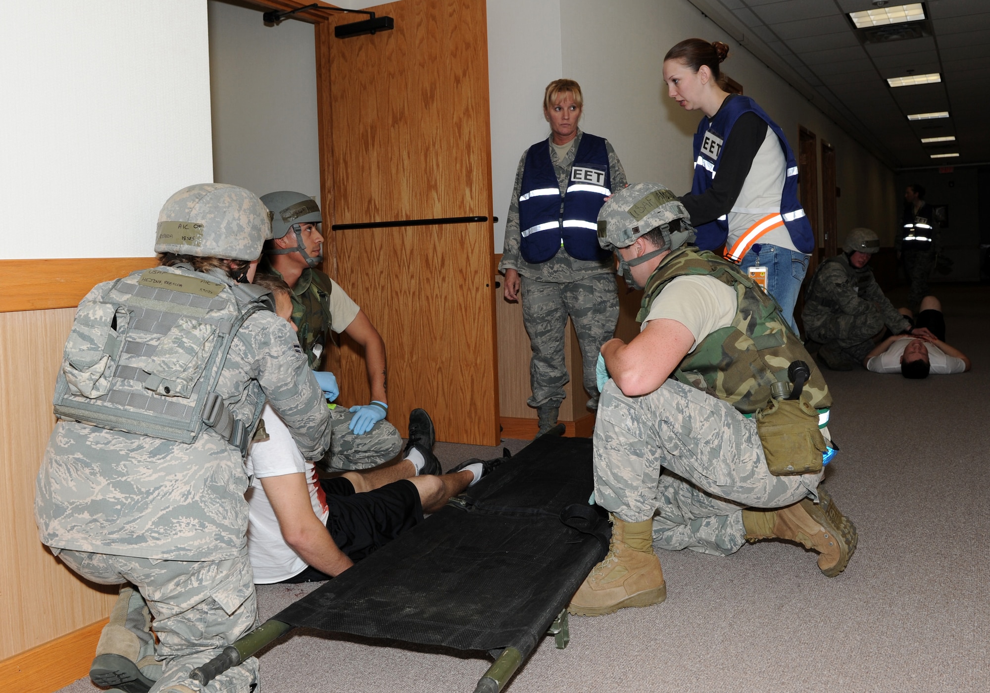 U.S. Air Force Capt. Cris Williams, 18th Medical Group exercise evaluation team member, and U.S. Air Force Staff Sgt. Cynthia Evans, 18th Dental Squadron EET member, both also moulage team members, guide players in the right way during an active shooter scenario at the 909th Air Refueling Squadron during Beverly High 12-1, a local operational readiness exercise on Kadena Air Base, Japan, Oct. 26. During the LORE, many EET members are on-scene to evaluate Airmen in ways such as safety and immediate reaction. (U.S. Air Force photo/Junko Kinjo/Released) 