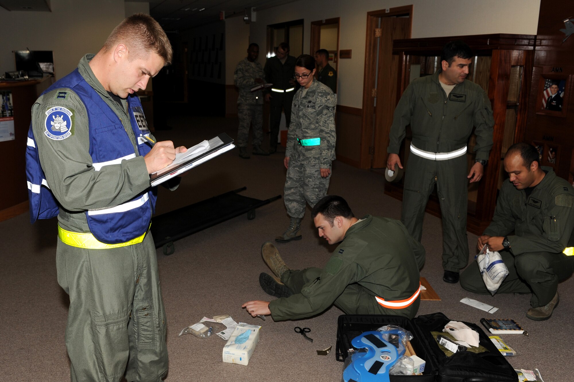 U.S. Air Force Capt. Stephen Grantier, 18th Operations Group exercise evaluation team member, evaluates how Airmen apply self-aid and buddy care during a suicide bomber scenario at the 909th Air Refueling Squadron during Beverly High 12-1, a local operational readiness exercise on Kadena Air Base, Japan, Oct. 25.  The 18th Wing is participating in the LORE Oct. 24-28 to test the readiness of Kadena Airmen. (U.S. Air Force photo/Junko Kinjo/Released) 