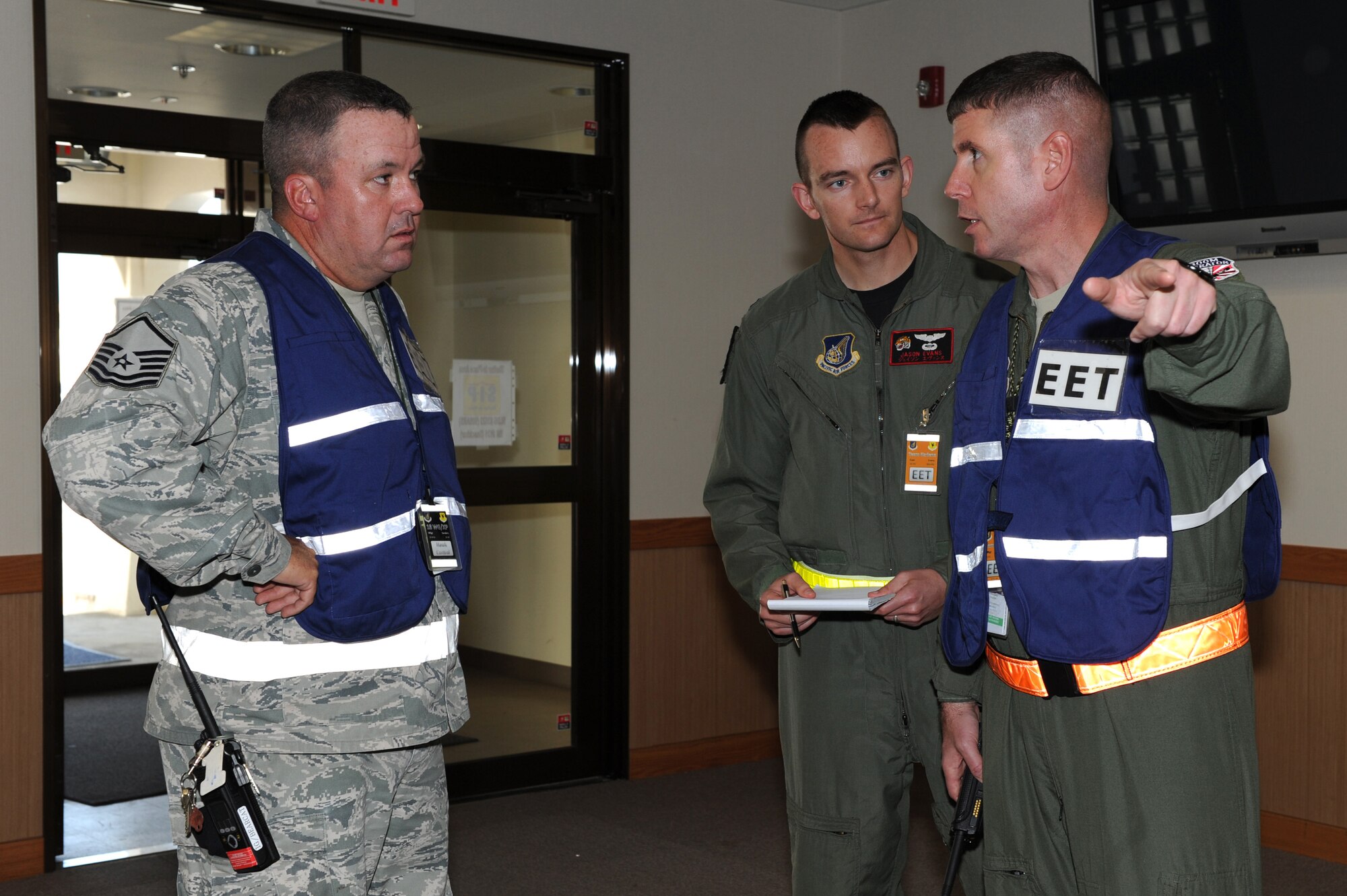 U.S. Air Force Master Sgt. Brent Sanders, Capt. Jason Evans, and Senior Master Sgt. Michael Steinkraus, 18th Wing exercise evaluation team members, discuss a suicide bomber scenario at the 909th Air Refueling Squadron during Beverly High 12-1, a local operational readiness exercise on Kadena Air Base, Japan, Oct. 25. During the LORE, many EET members are on-scene to evaluate Airmen in ways such as safety and immediate reaction. (U.S. Air Force photo/Junko Kinjo/Released) 