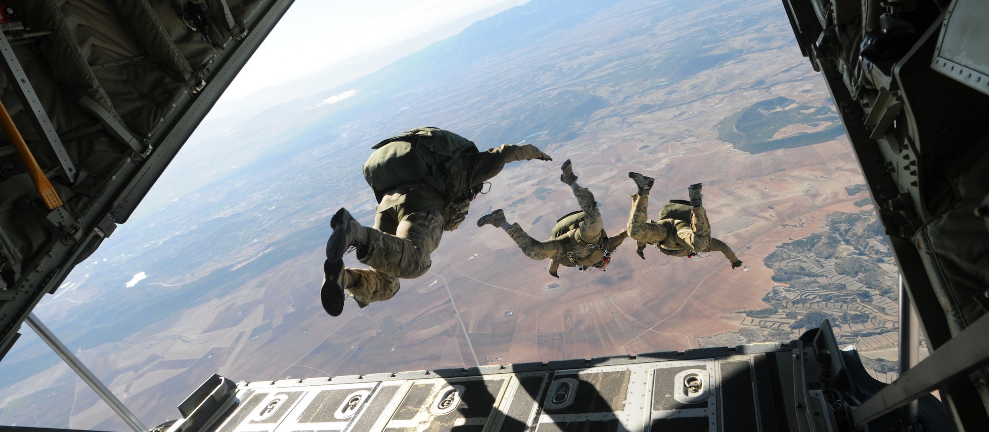WESTERN EUROPE – Tech. Sgt. Jeremy Diola (left), Staff Sgt. Craig Patterson, 56th Rescue Squadron pararescuemen, Master Sgt.  Louis Distelzweig, 56th RQS pararescue superintendent, leap out the of a C-130J Hercules, Oct. 25, 2011. 56th RQS pararescuemen jumped with other European Air Group forces as a part of the annual European Air Group Combined Joint Personnel Standardization Course 2011.  (U.S. Air Force photo by Airman Cory D. Payne)