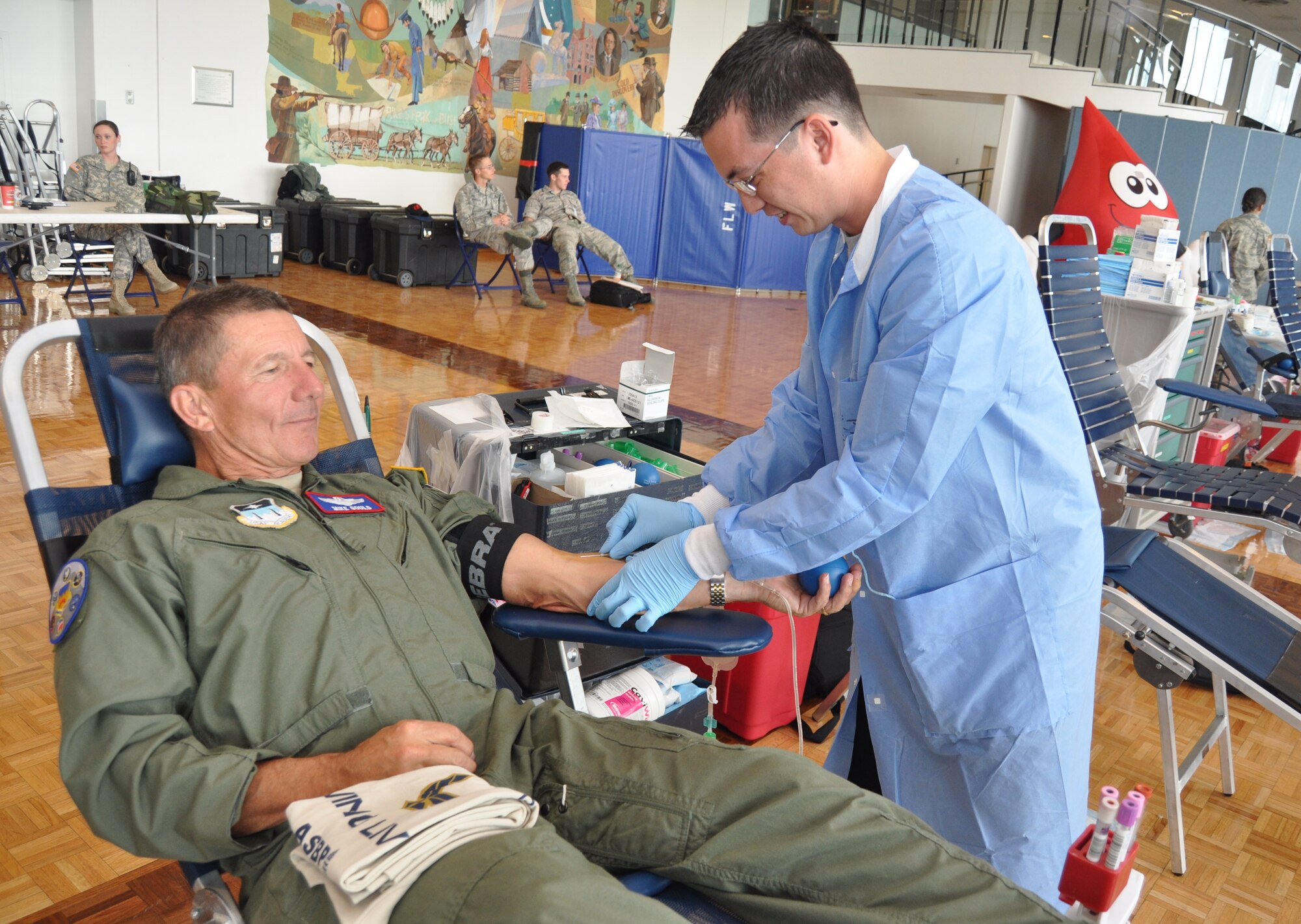 Kevin Nguyen from Keesler Air Force Base, Miss., begins drawing blood from Air Force Academy Superintendent Lt. Gen. Michael Gould.  Gould is a former commander of 2nd Air Force at Keesler.  (Courtesy photo by Lori Kuczmanski)