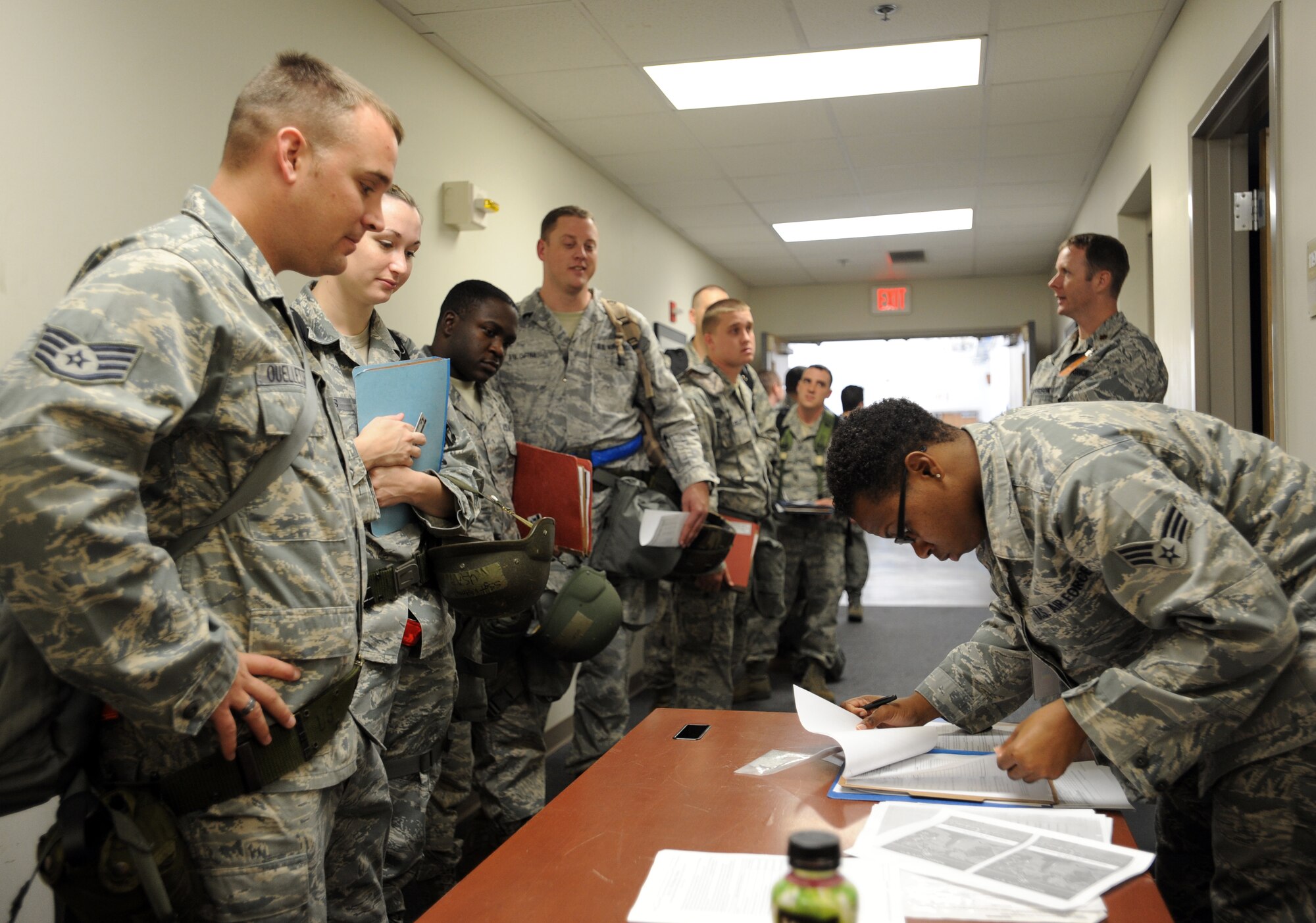 U.S. Air Force Senior Airman Amanda Taylor, 20th Force Support Squadron career development supervisor, looks through Airmen's mobility folders before they process through the line at Shaw Air Force Base, S.C., Oct. 26, 2011. This week the Phase I exercise Sea Lion 12-01 kicked off giving Shaw Airmen the opportunity to train and simulate the process before deploying. (U.S. Air Force photo by Airman 1st Class Tabatha Duarte/Released)