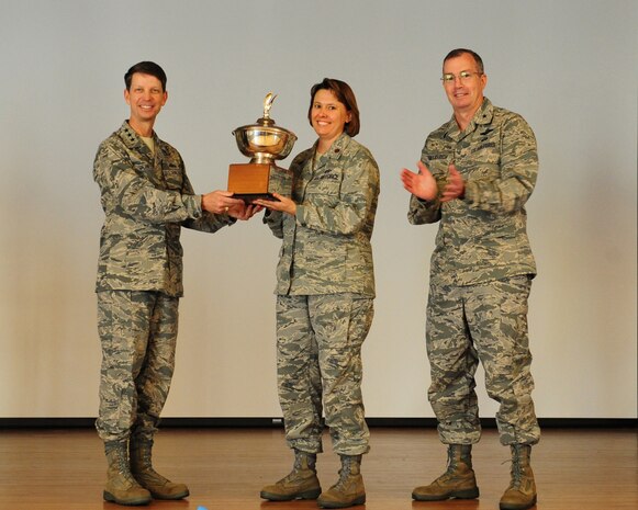 Lieutenant General Darrell D. Jones (left) and Brigadier General Paul H. McGillicuddy (right) present the 2011 Eubank award trophy to Major Connie May, 9th Force Support Squadron commander, during a ceremony Oct. 25, 2011 at Beale Air Force Base, California. The Eubank award recognizes the best installation level force support squadrons evaluating them in mission accomplishment, leadership, innovation, management, customer focus, and customer impact. The award is presented annually to recognize excellence at small bases where there are less than 5,000 Airmen assigned. The award namesake was Maj. Gen. Eugene L. Eubank, a highly decorated pilot who served more than 34 years in the Air Force. General Eubank recognized the importance of morale and welfare for America's fighting forces to further the overall Air Force mission. The Order of Daedalian Foundation established the award in 1990. (U.S. Air Force photo/Mr. John Schwab)
