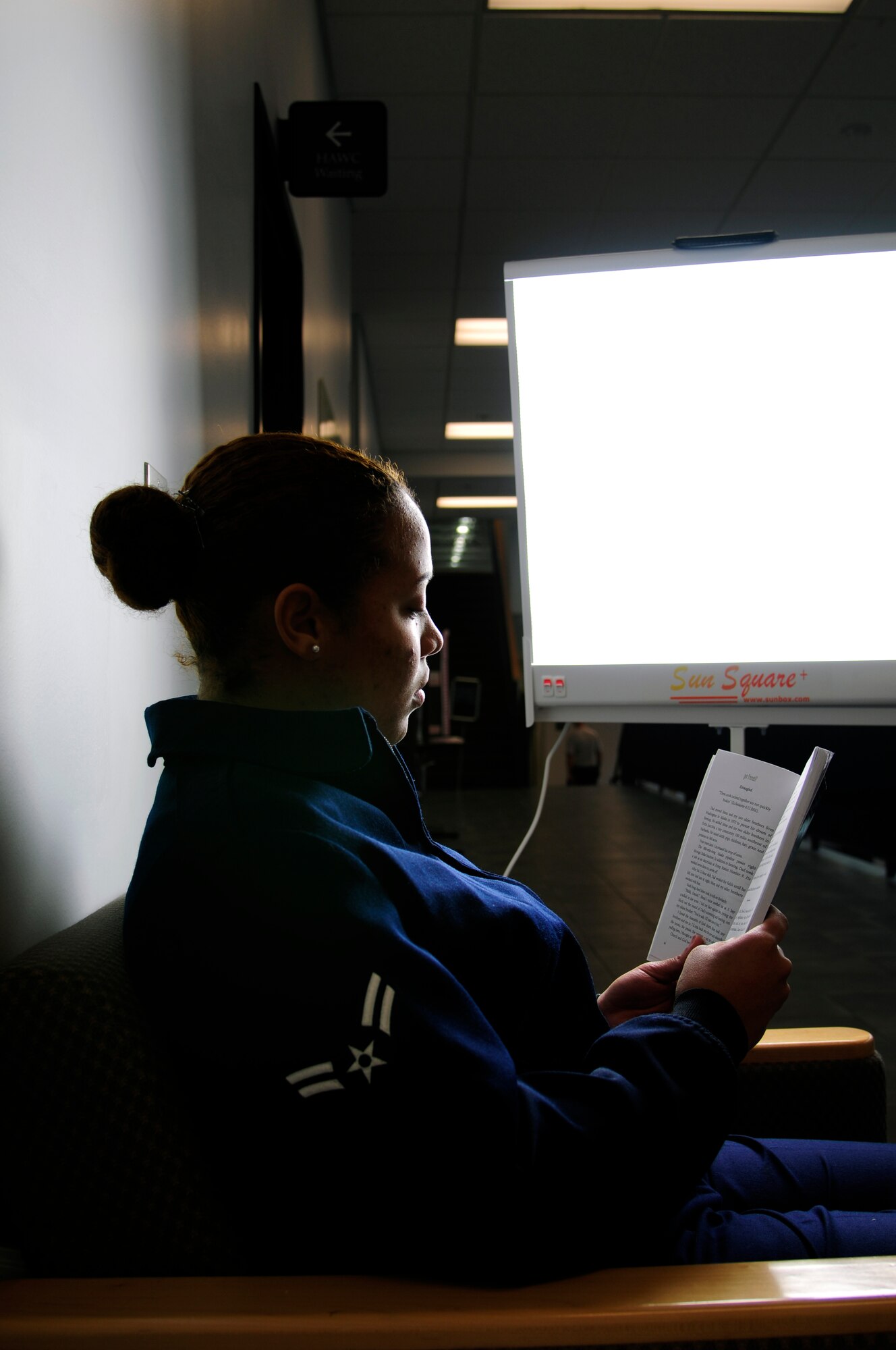 U.S. Air Force Airman 1st Class Martina Nielsen, 354th Communications Squadron information manager, reads under a happy light Oct. 17, 2011, Eielson Air Force Base, Alaska.  Light therapy absorbed in a natural or artificial setting is considered one of the best ways to combat winter depression. (U.S. Air Force photo by Airman 1st Class Yash Rojas/released)