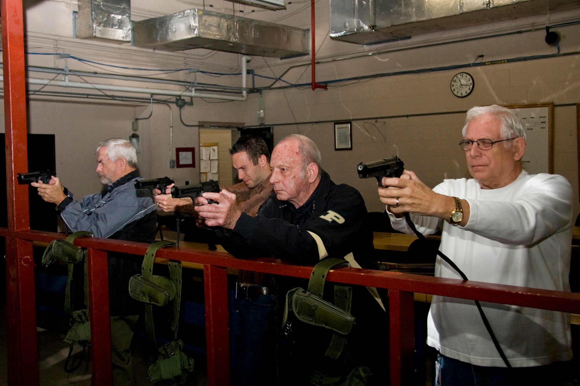 GRISSOM AIR RESERVE BASE, Ind. -- Grissom's honorary commanders shoot M-9 pistols during a special firearms simulator demonstration here Oct. 14. From left to right are Hal Job, Rocky Walls, John Gilpin and John Stackhouse. The group visited the base that day to learn more about the 434th Mission Support Group. The honorary commander program at Grissom is just one of several community outreach programs aimed at educating the public about Grissom's mission and impact on the community.  (U.S. Air Force photo/Tech. Sgt. Mark R. W. Orders-Woempner)    
