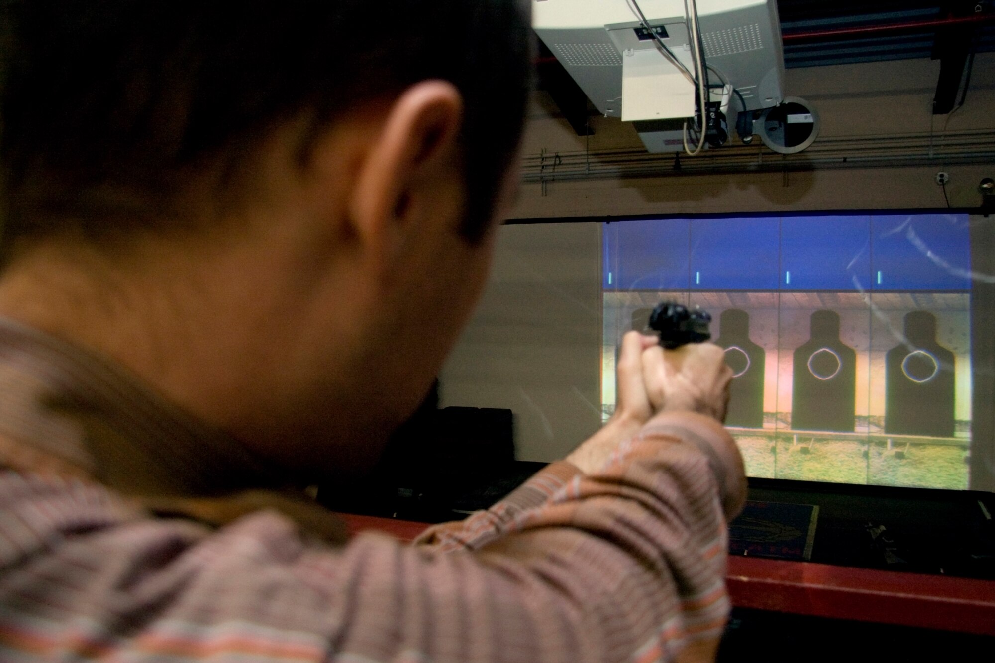 GRISSOM AIR RESERVE BASE, Ind. -- Rocky Walls, 434th Mission Support Group honorary commander, takes aim down the barrel of an M-9 pistol during a special firearms simulator demonstration here Oct. 14. Walls, along with Grissom's other honorary commanders visited the base that day to learn more about the 434th MSG. The honorary commander program at Grissom is just one of several community outreach programs aimed at educating the public about Grissom's mission and impact on the community.  (U.S. Air Force photo/Tech. Sgt. Mark R. W. Orders-Woempner)    
