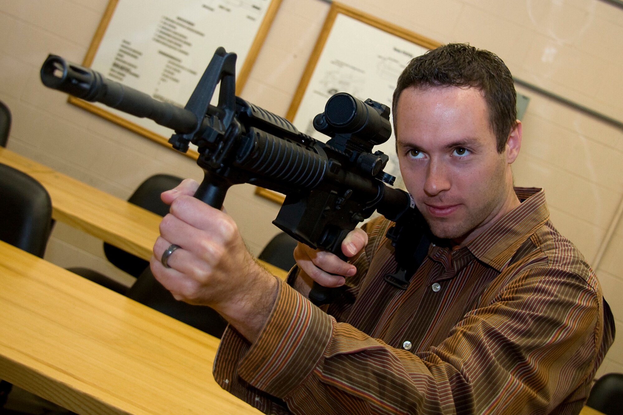 GRISSOM AIR RESERVE BASE, Ind. -- Rocky Walls takes aim down the barrel of an M-4 carbine rifle during a special firearms simulator demonstration here Oct. 14. Walls, along with Grissom's other honorary commanders visited the base that day to learn more about the 434th MSG. The honorary commander program at Grissom is just one of several community outreach programs aimed at educating the public about Grissom's mission and impact on the community.  (U.S. Air Force photo/Tech. Sgt. Mark R. W. Orders-Woempner)    

