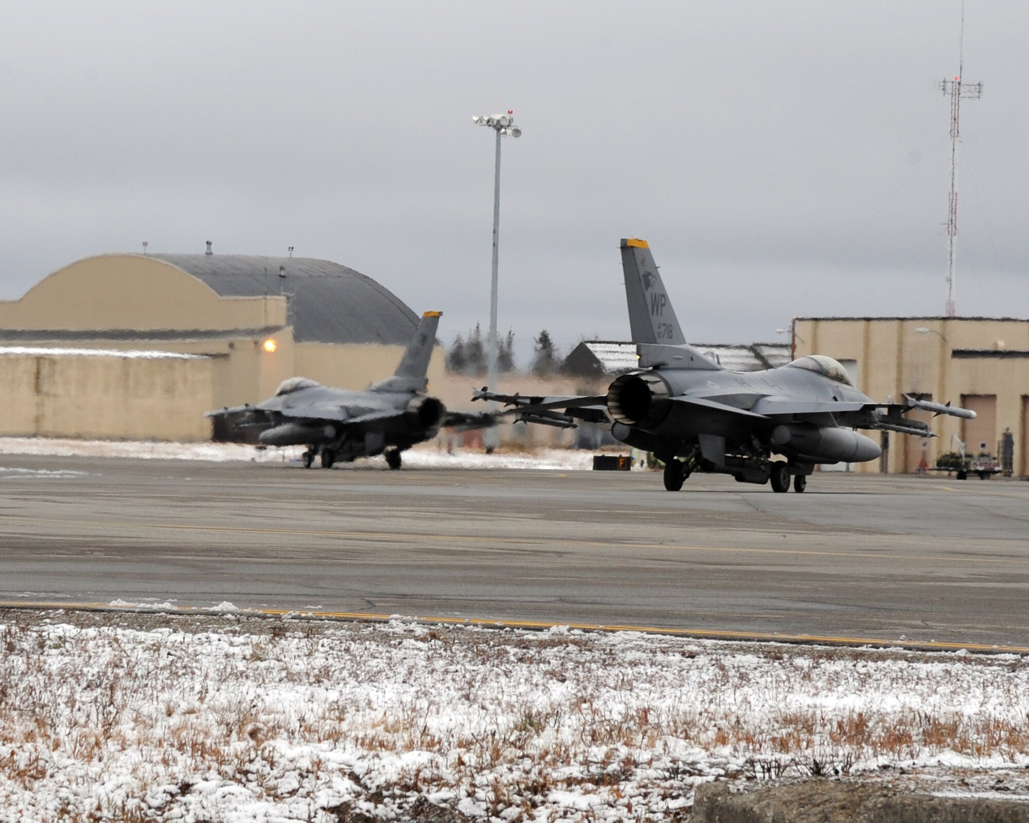 Two U.S. Air Force F-16 Fighting Falcons assigned to Kunsan Air Base, Republic of Korea taxi down the flightline at Eielson Air Force Base, Alaska, Oct. 18, 2011. The F-16's are participating in exercise RED FLAG-Alaska, a two-week long air combat exercise. (U.S. Air Force photo by Senior Airman Willard E. Grande II)