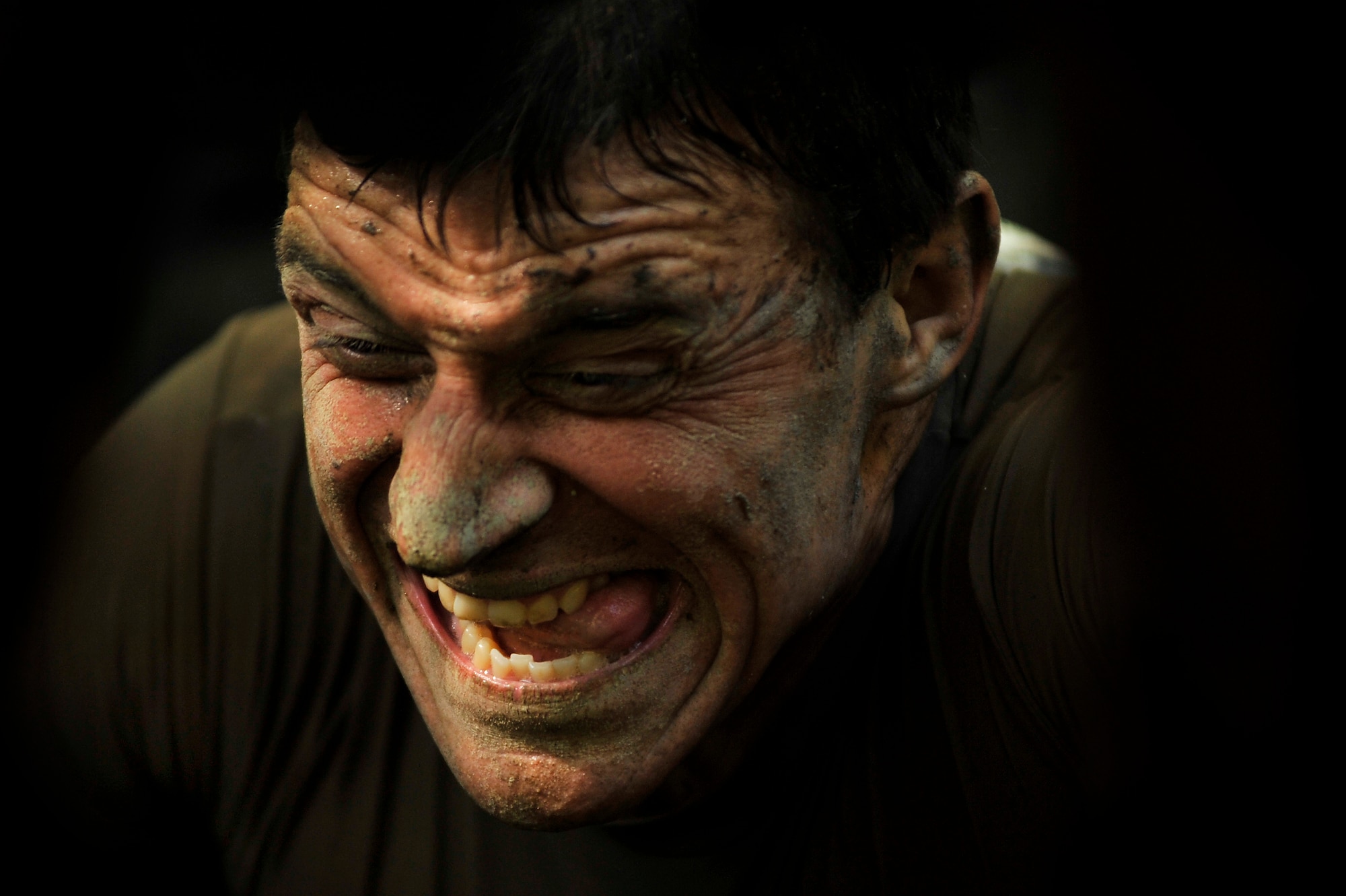 The look of dedication and intensity is displayed on the face of an U.S. Marine Corps Mud Run participant, as he low crawls through mud in order to reach the next check point of the race, Oct. 15, 2011, Columbia, S.C. Participants competed in four person teams in different categories: male, female, co-ed, homeland heroes, military, corporate and JROTC. (U.S. Air Force photo by Senior Airman Kenny Holston/Released)


