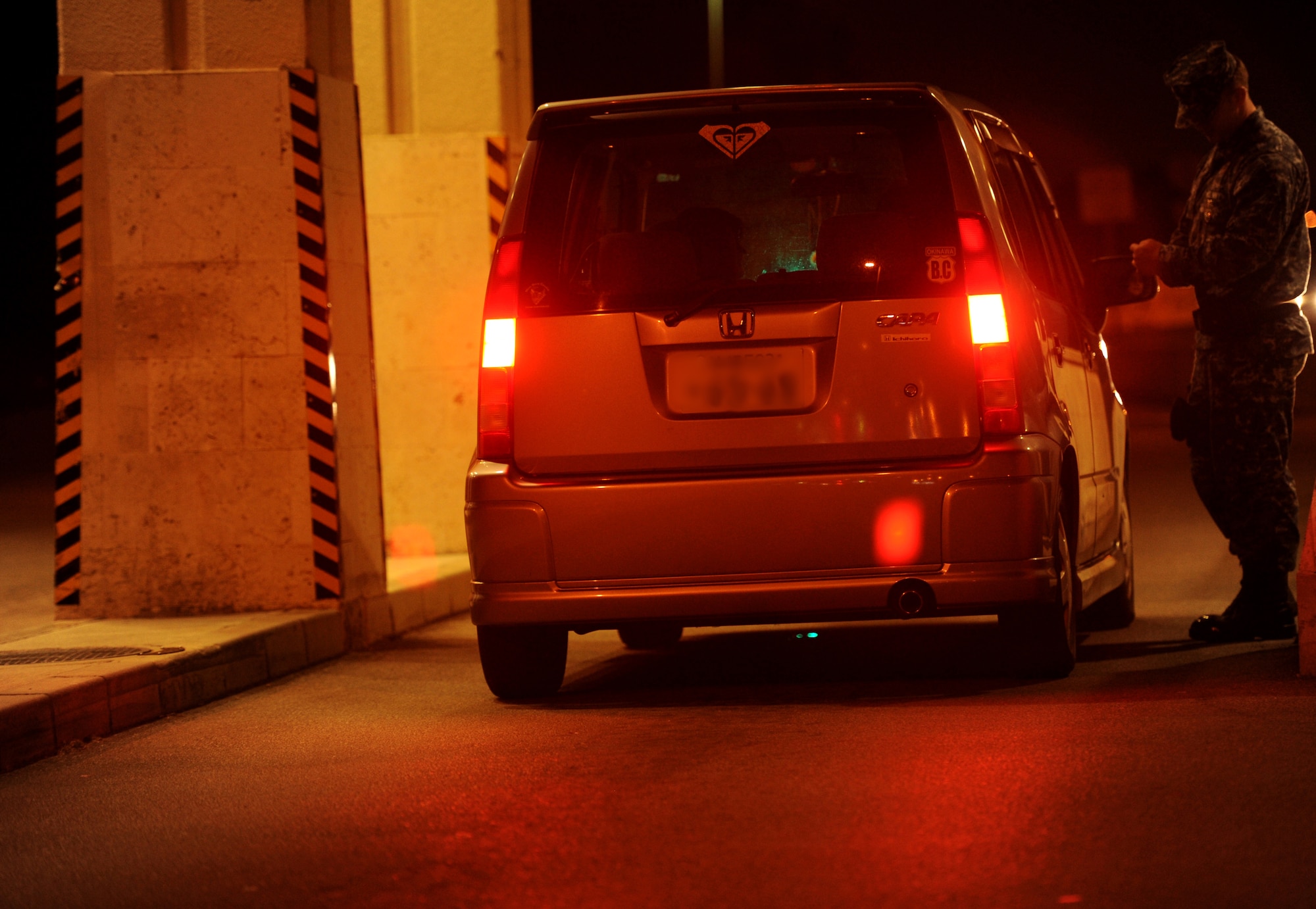 U.S. Navy Petty Officer 3rd Class Thomas Root, a master at arms attached to the 18th Security Forces Squadron, checks the identification card of a military dependent Oct. 26 on Kadena Air Base, Japan. Although Team Kadena is currently participating in local operational readiness exercise Beverly High 12-1, real-world mission requirements must still be met. (U.S. Air Force photo/Airman 1st Class Jarvie Z. Wallace/released)
