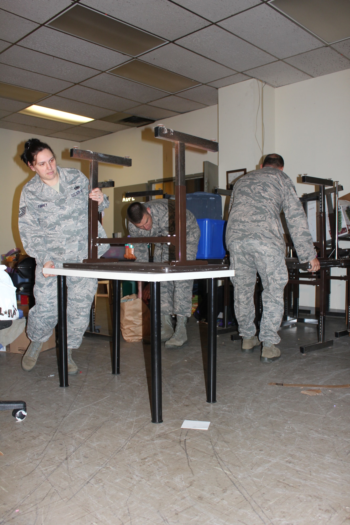 Tech. Sgt. Merrilee Finney, Staff Sgt. Daniel Merlin and Tech. Sgt. Chad Hall, all from 621st Contingency Response Wing, organize tables in preparation for the grand reopening of the Attic which is set to open at 10 a.m. Oct. 24. After a week-long of renovations, the Attic will open from 10 a.m. to 2 p.m. Monday, Wednesday and Fridays. The Attic is open to all military branches from all ranks. The Attic accepts donations such as clothing, furniture and household items. Call Tech. Sgt. Finney at 754-8703 for more information or to volunteer. (U.S. Air Force photo by Tech. Sgt. Francis Lalic/Released)